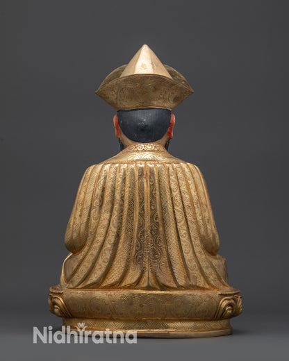 Back view of Guru Shapdum statue with ornate robe patterns and gold fire-gilded base