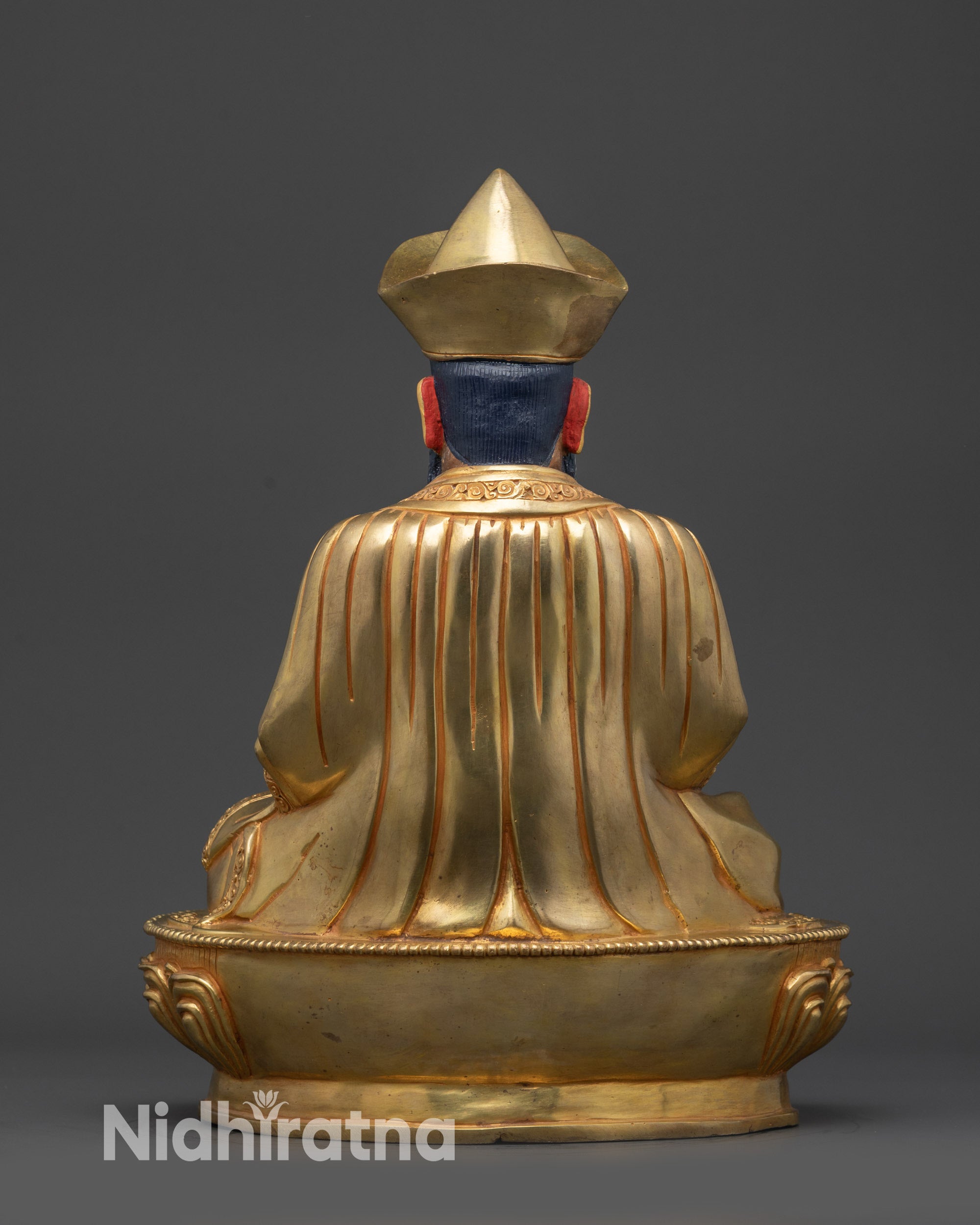 Back view of Guru Shapdum statue with ornate robes and gold fire-gilded base