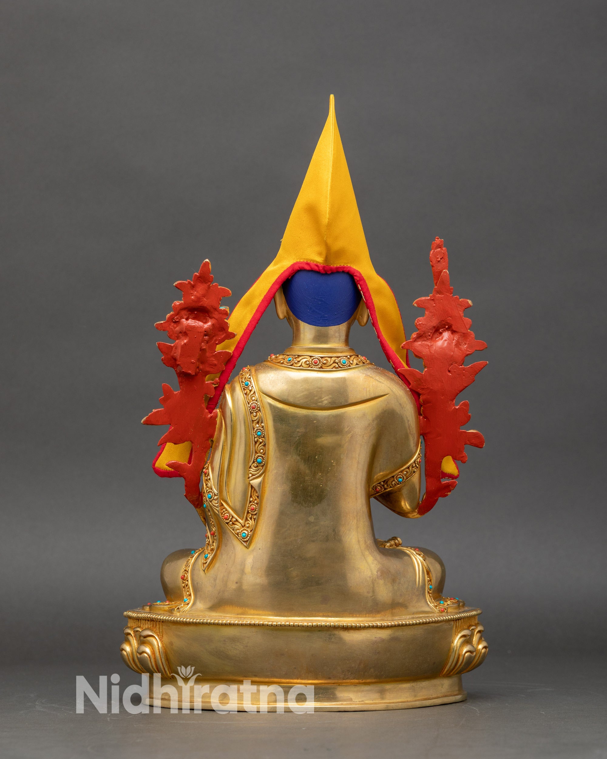 Back view of Je Tsongkhapa statue showing flowing brocade trim, lotus pedestal, and intricate craftsmanship