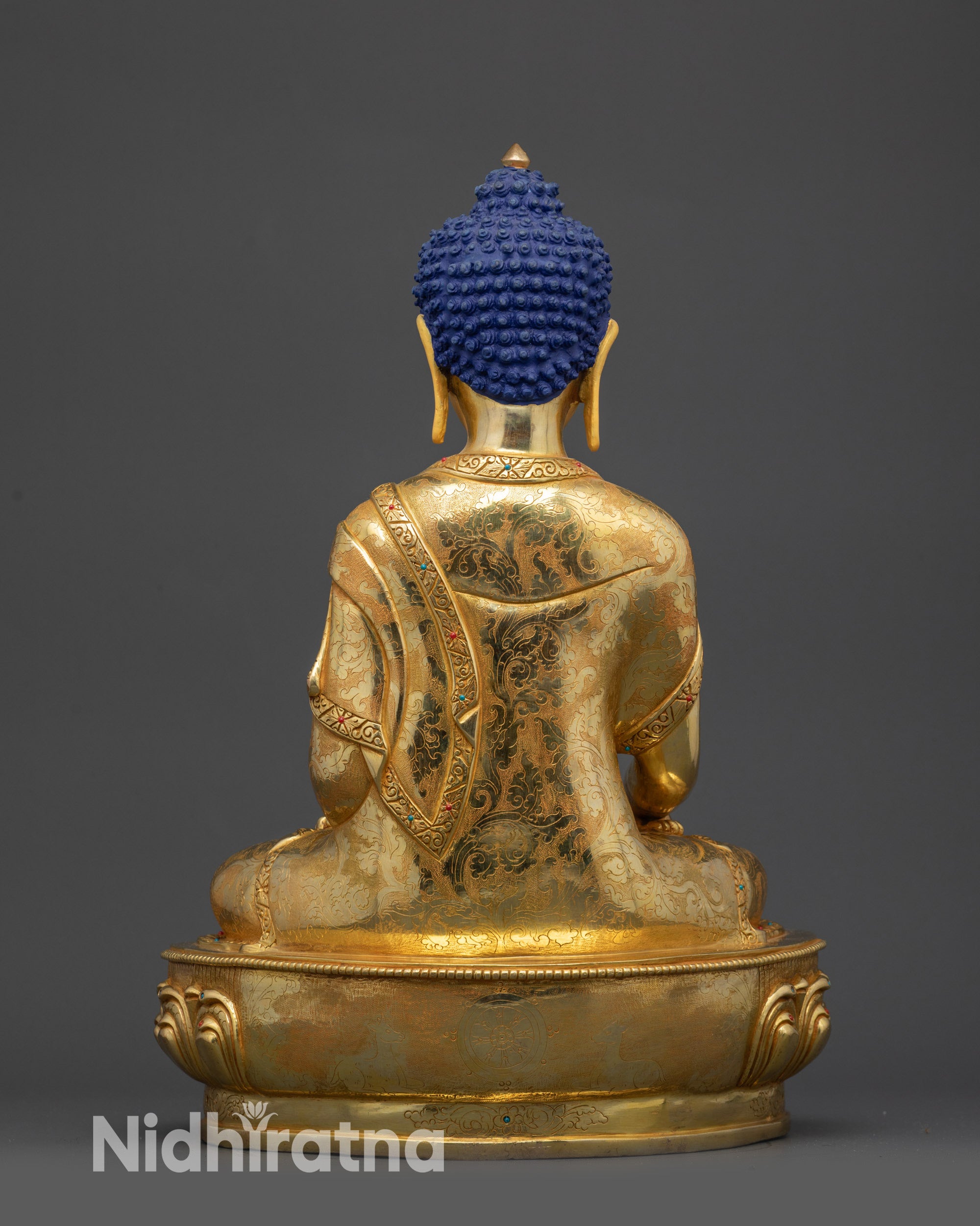 Back view of Lord Gautama Buddha statue showing detailed garments and patterns