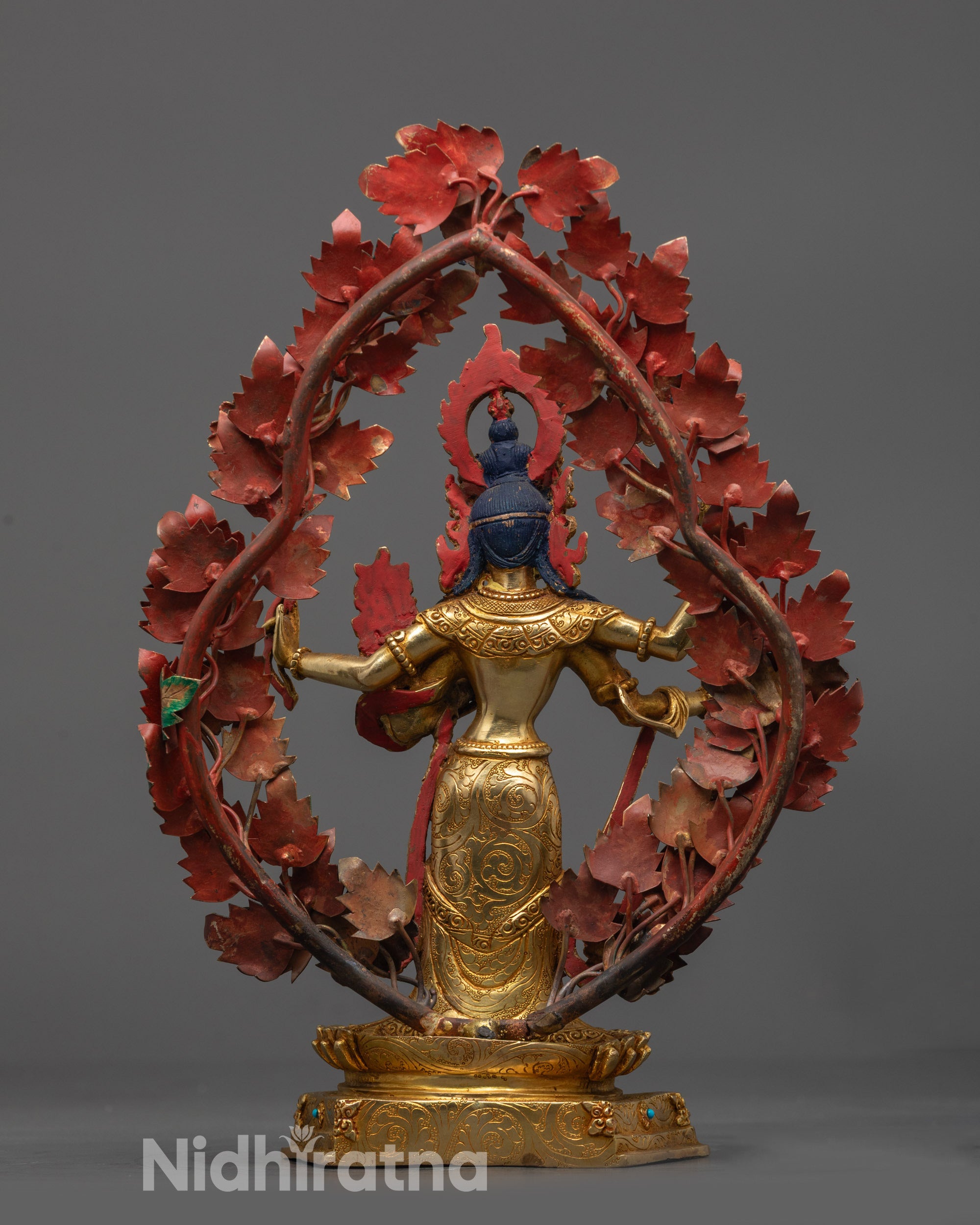 Back view of Maha Manjushri sculpture showing floral halo and detailed carvings on throne
