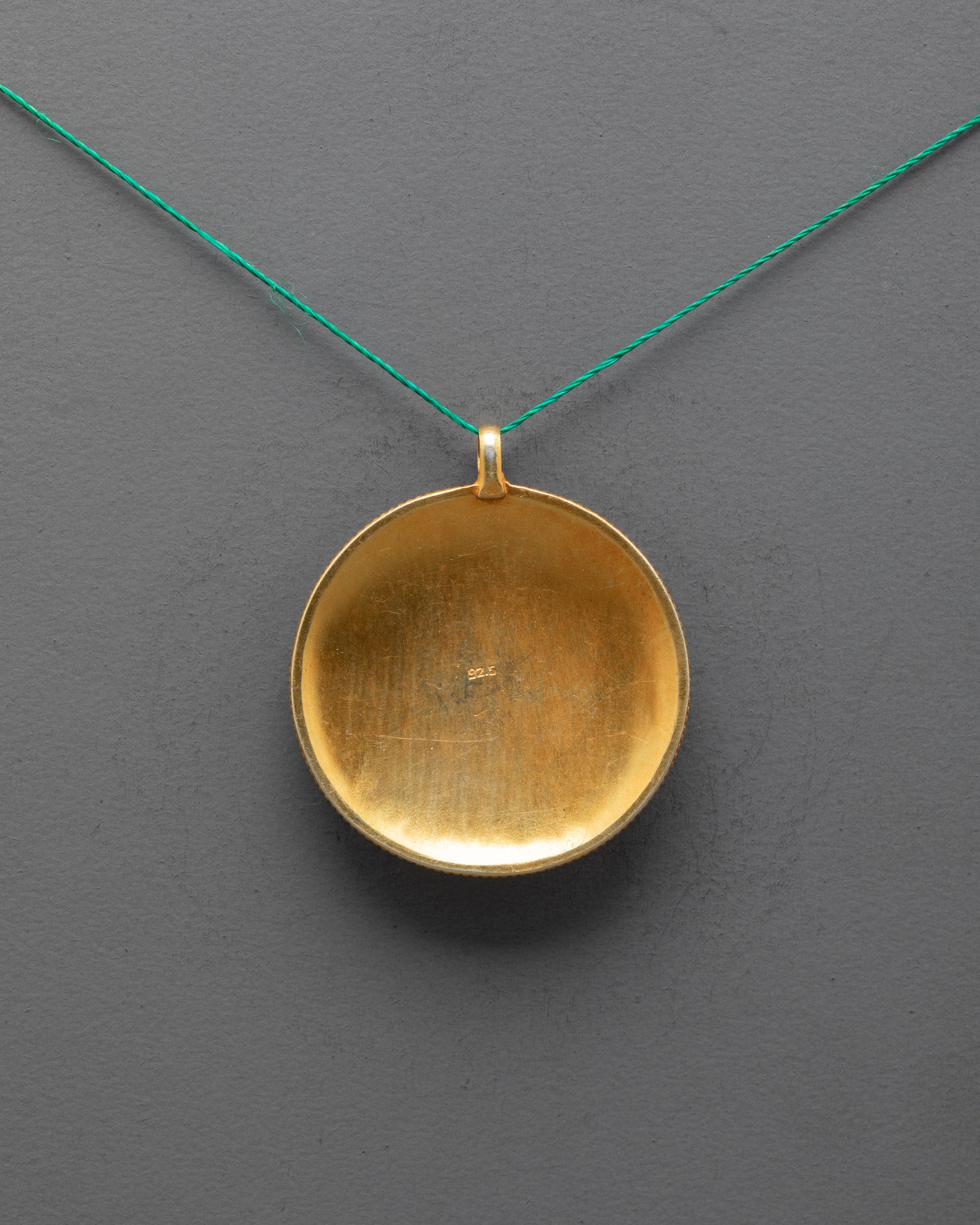 Back view of Mandala Locket highlighting traditional craftsmanship and carved patterns