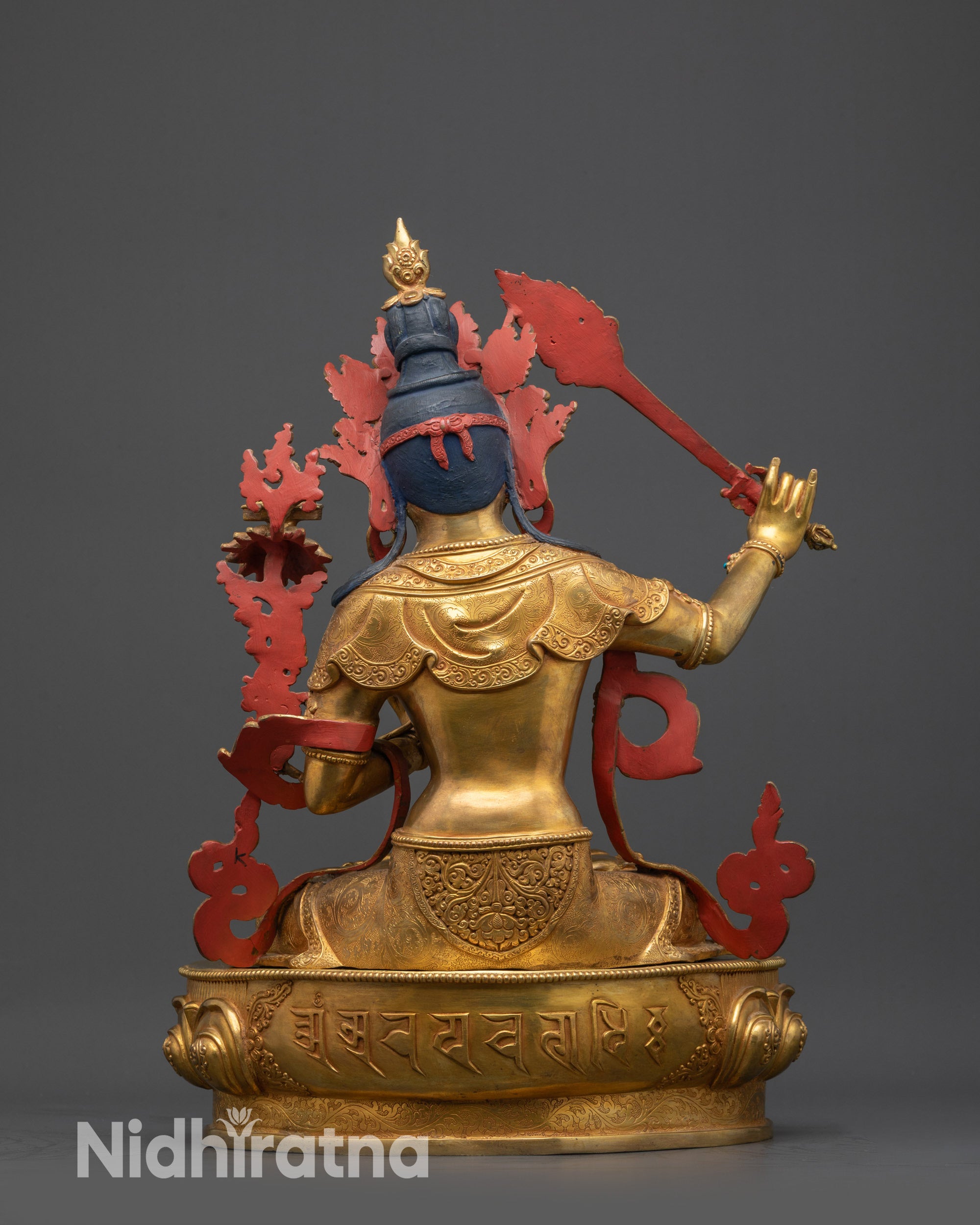 Back view of Manjushri Statue revealing carved robes and lotus seat with sacred mantra
