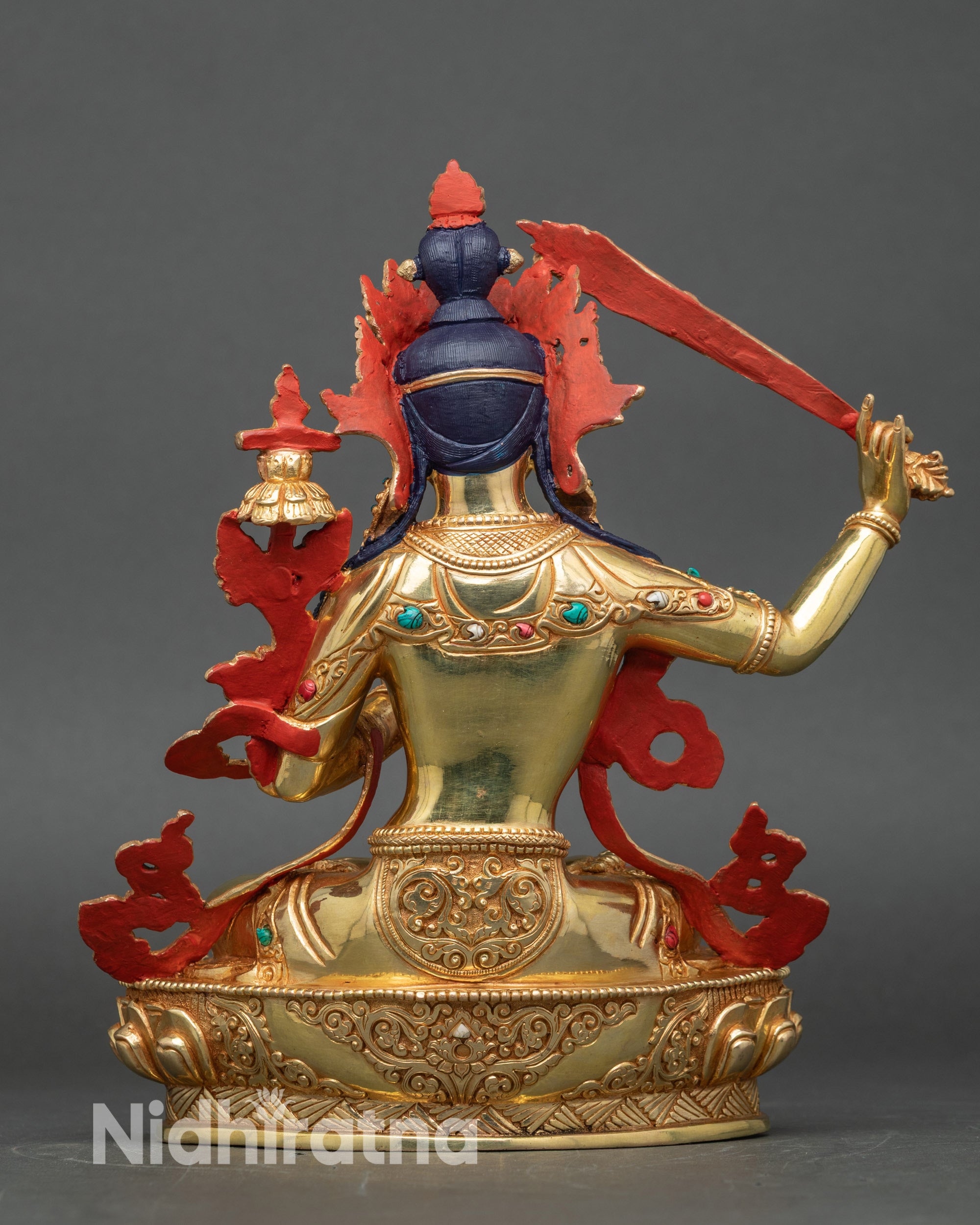 Back view of Manjushri sculpture, lotus pedestal and engraved robes in traditional Nepalese style