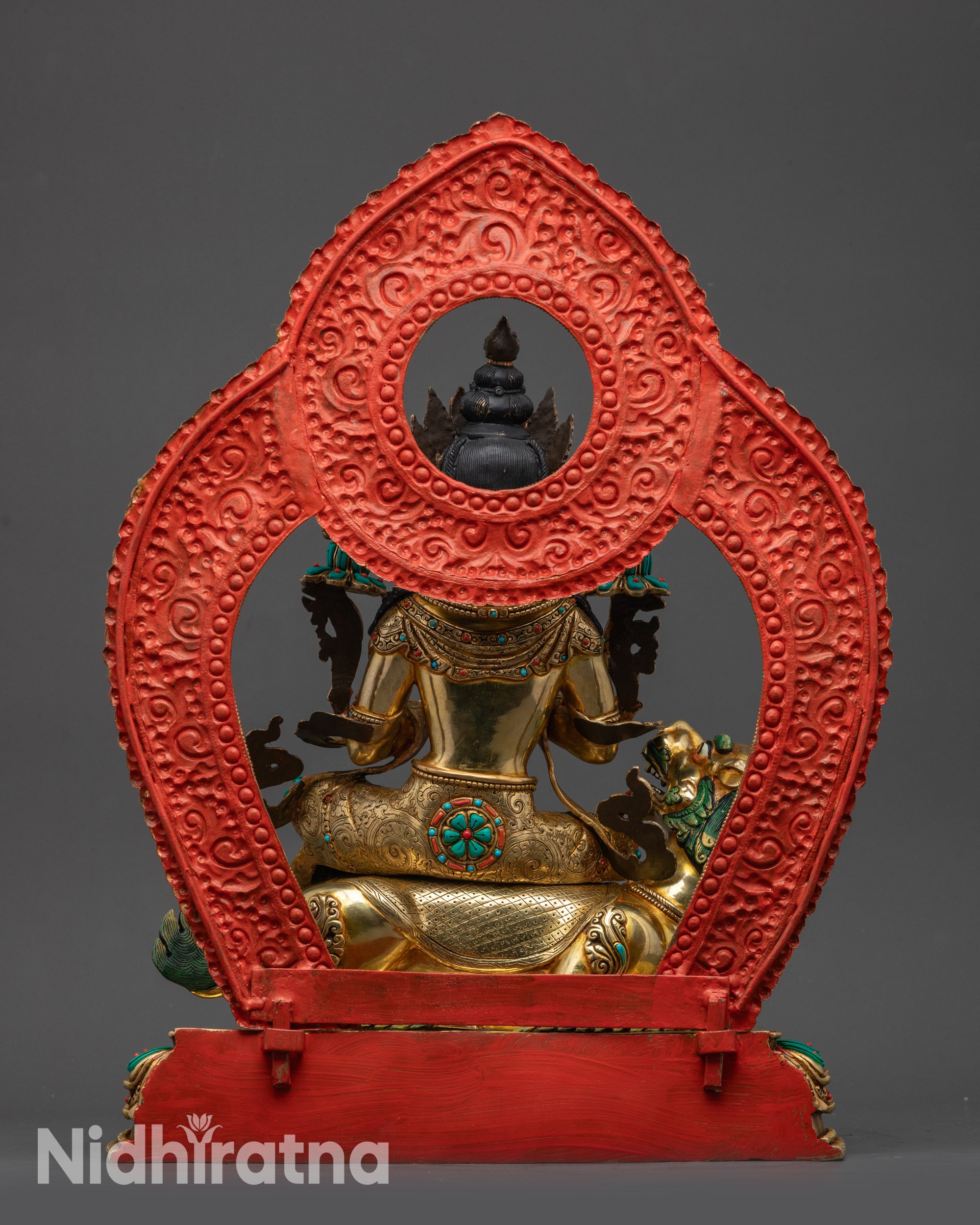 Back view of Manjushri statue showing intricate robe patterns and gold-gilded base