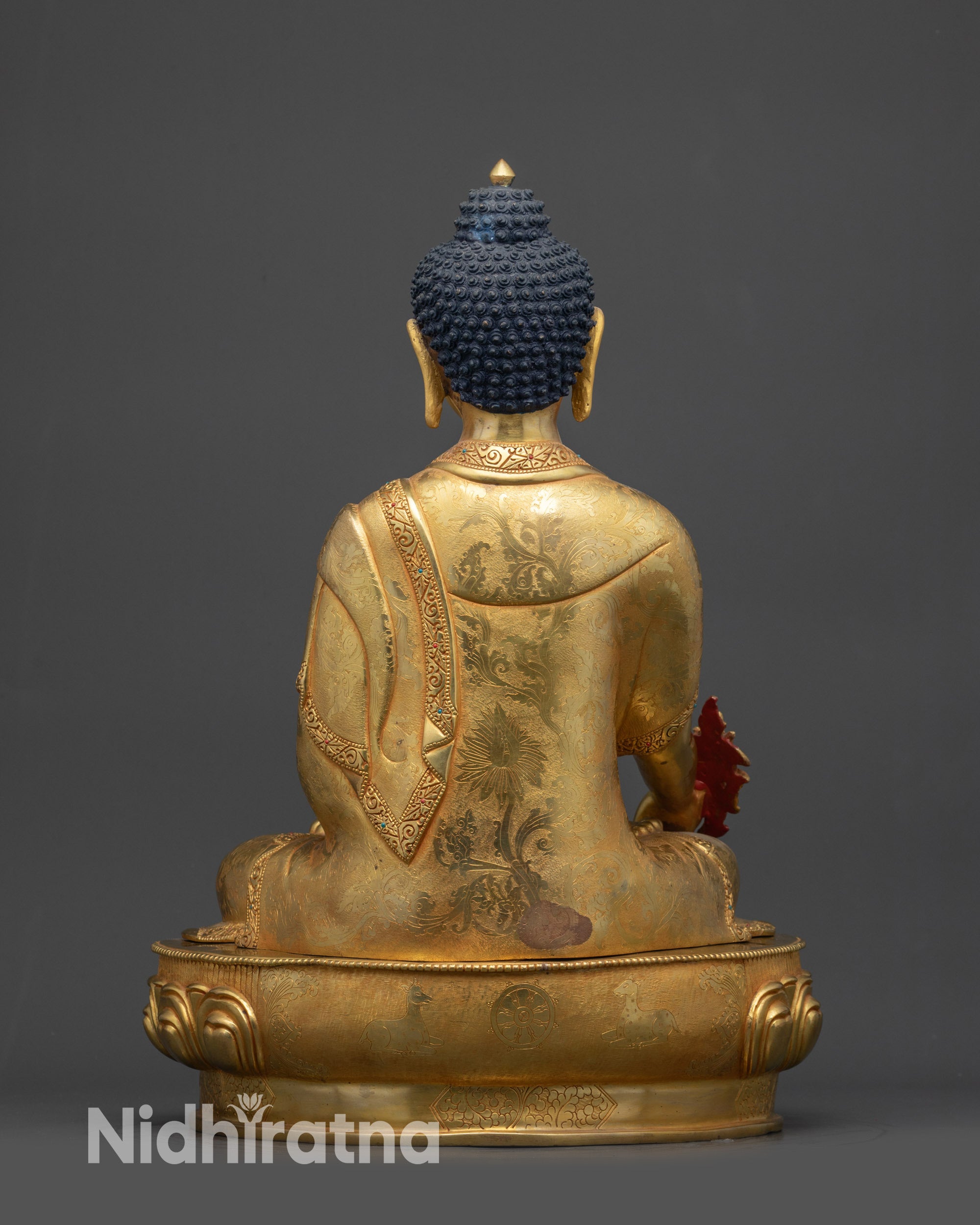 Back view of Medicine Buddha Bhaisajyaguru showing carved robes and lotus base patterns