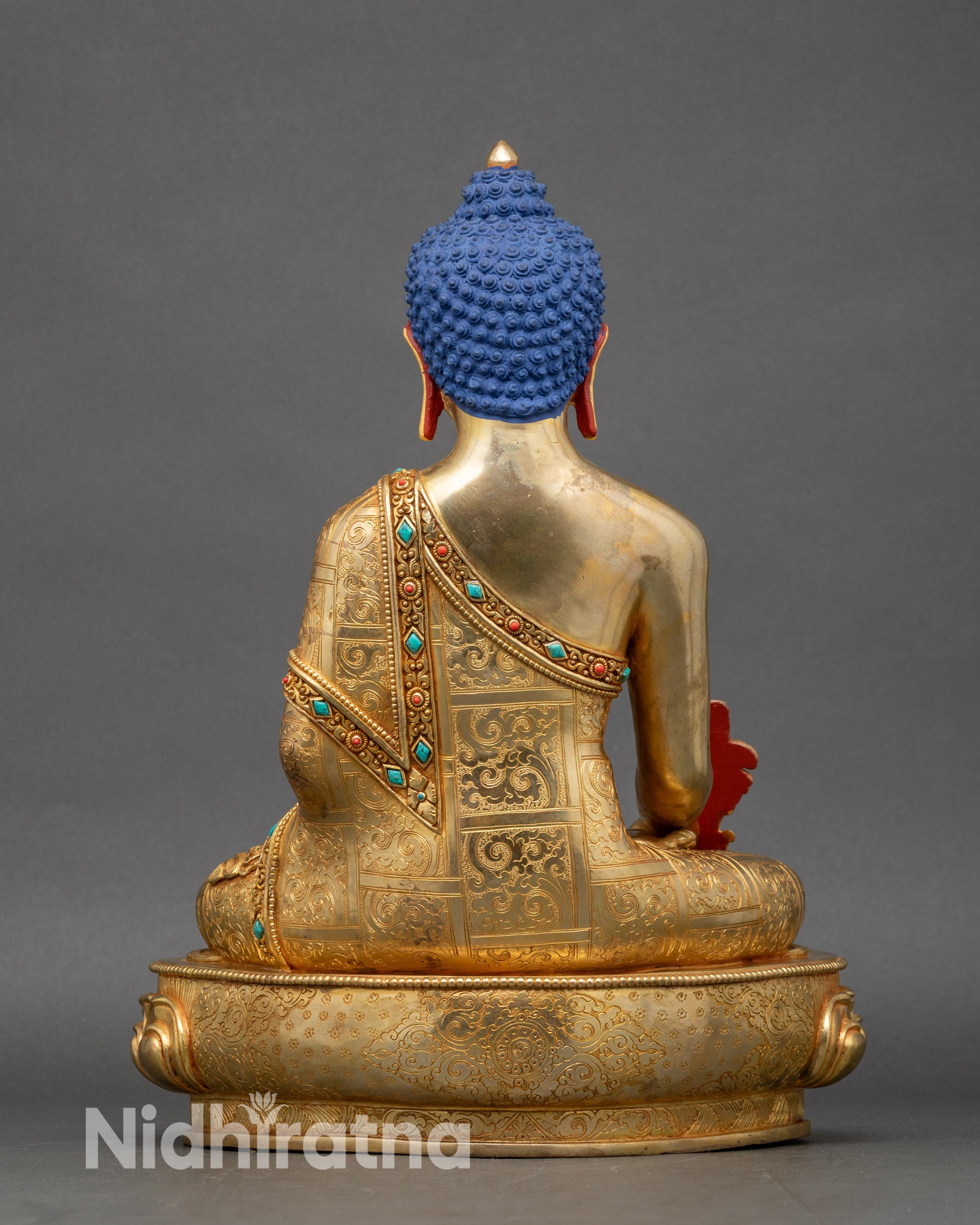 Back view of Medicine Buddha statue, engraved lotus throne and traditional Nepalese motifs