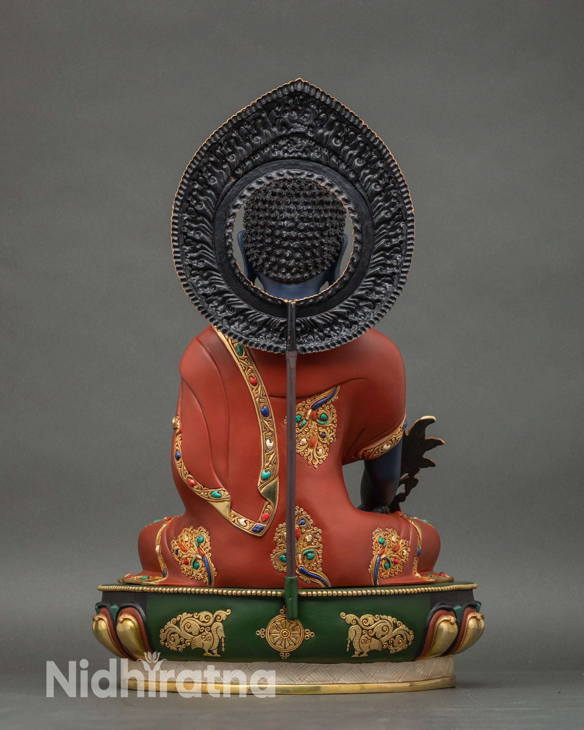 Back view of Medicine Buddha statue showing halo and monk garment details, Nepalese craftsmanship