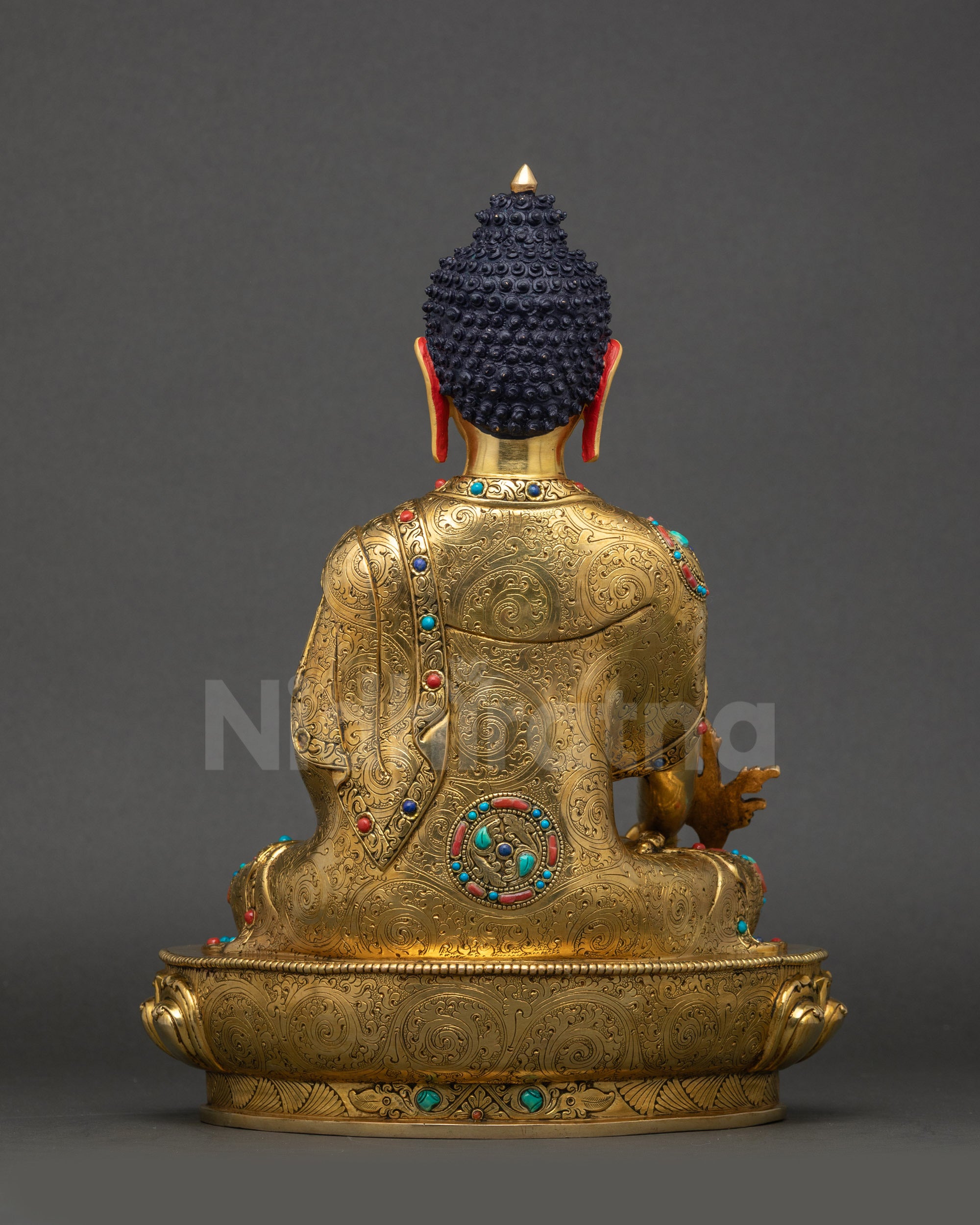 Back view of Medicine Buddha statue showing intricate robes and traditional craftsmanship