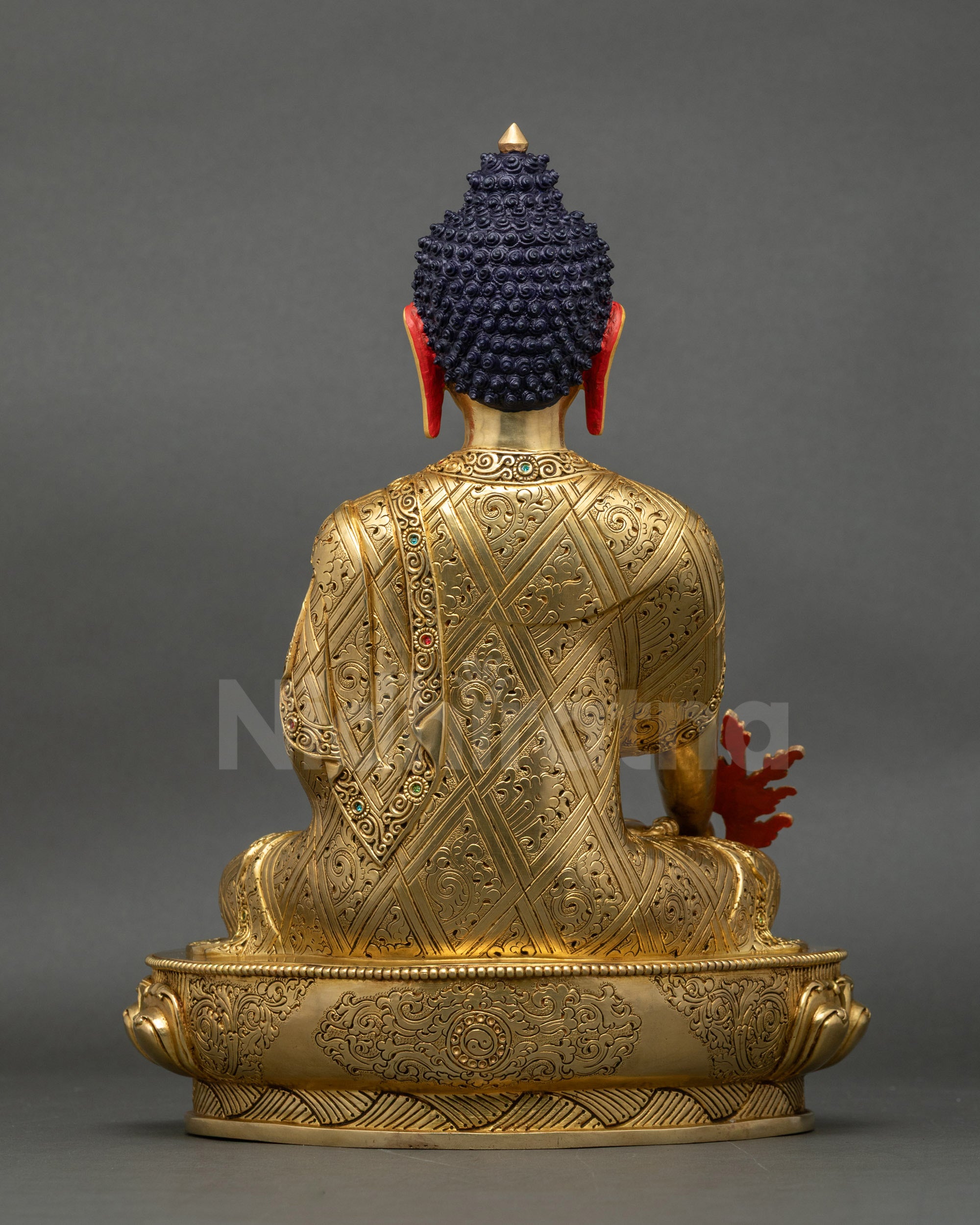 Back view of Medicine Buddha statue showing lotus base and detailed floral motif carvings
