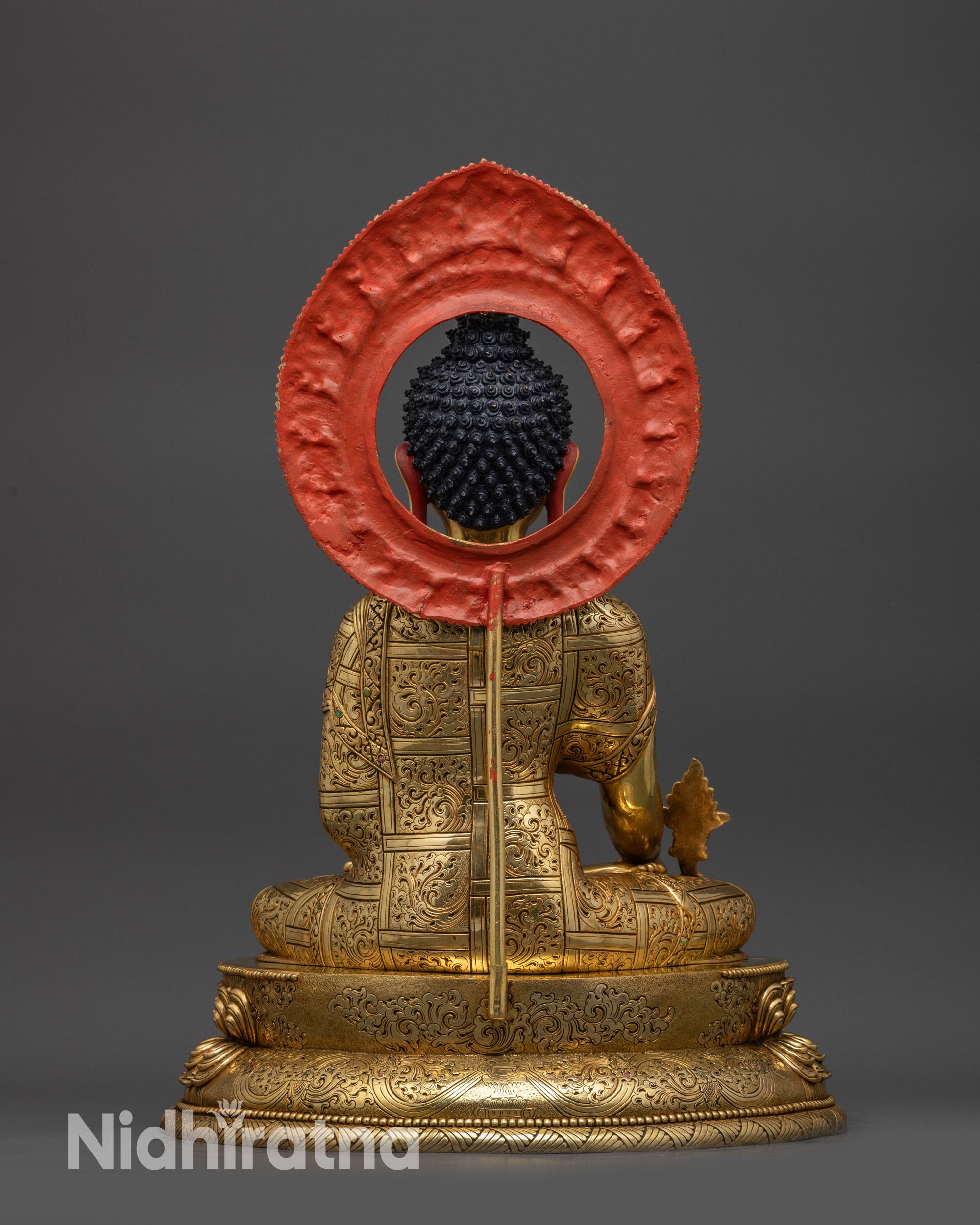 Back view of Medicine Buddha statue with detailed robe patterns and copper finish