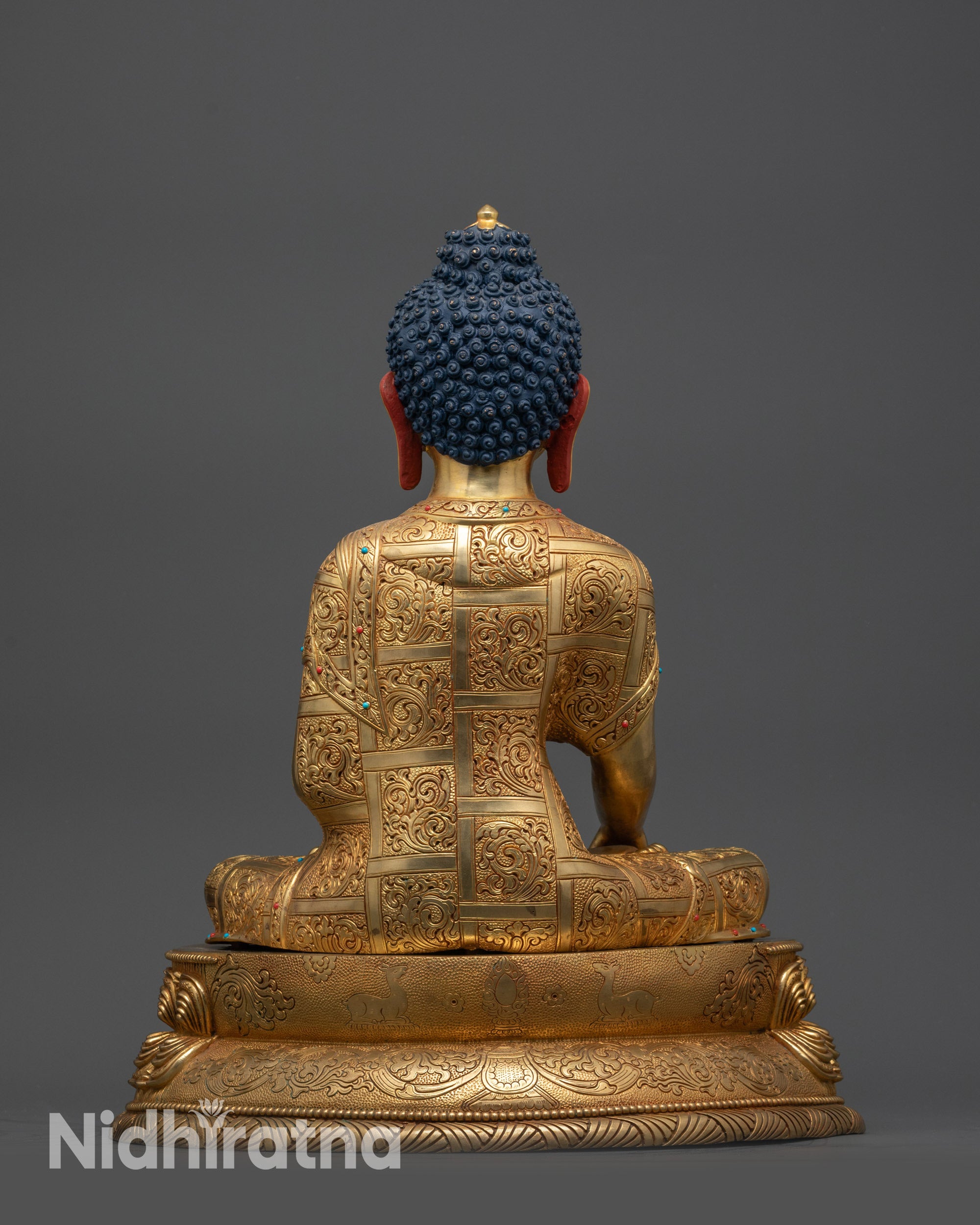 Back view of Nepalese Buddha statue showing carved robe and majestic lotus seat