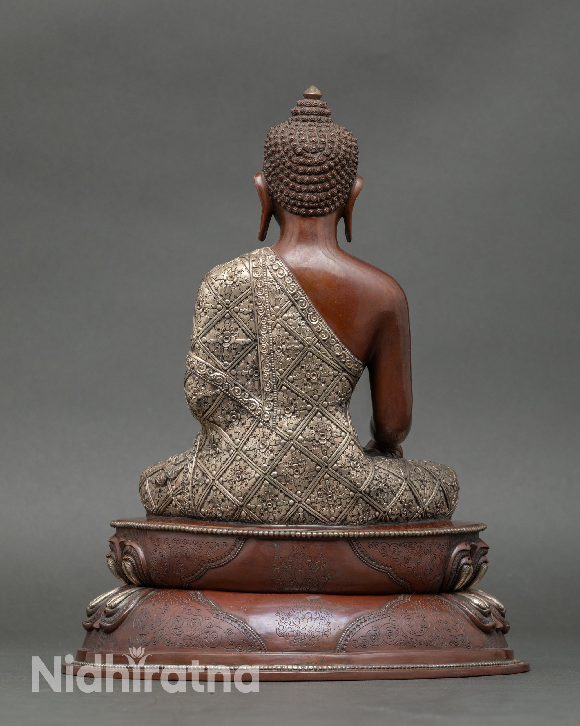 Back view of Nepalese Buddha statue showing detailed robes and lotus pedestal