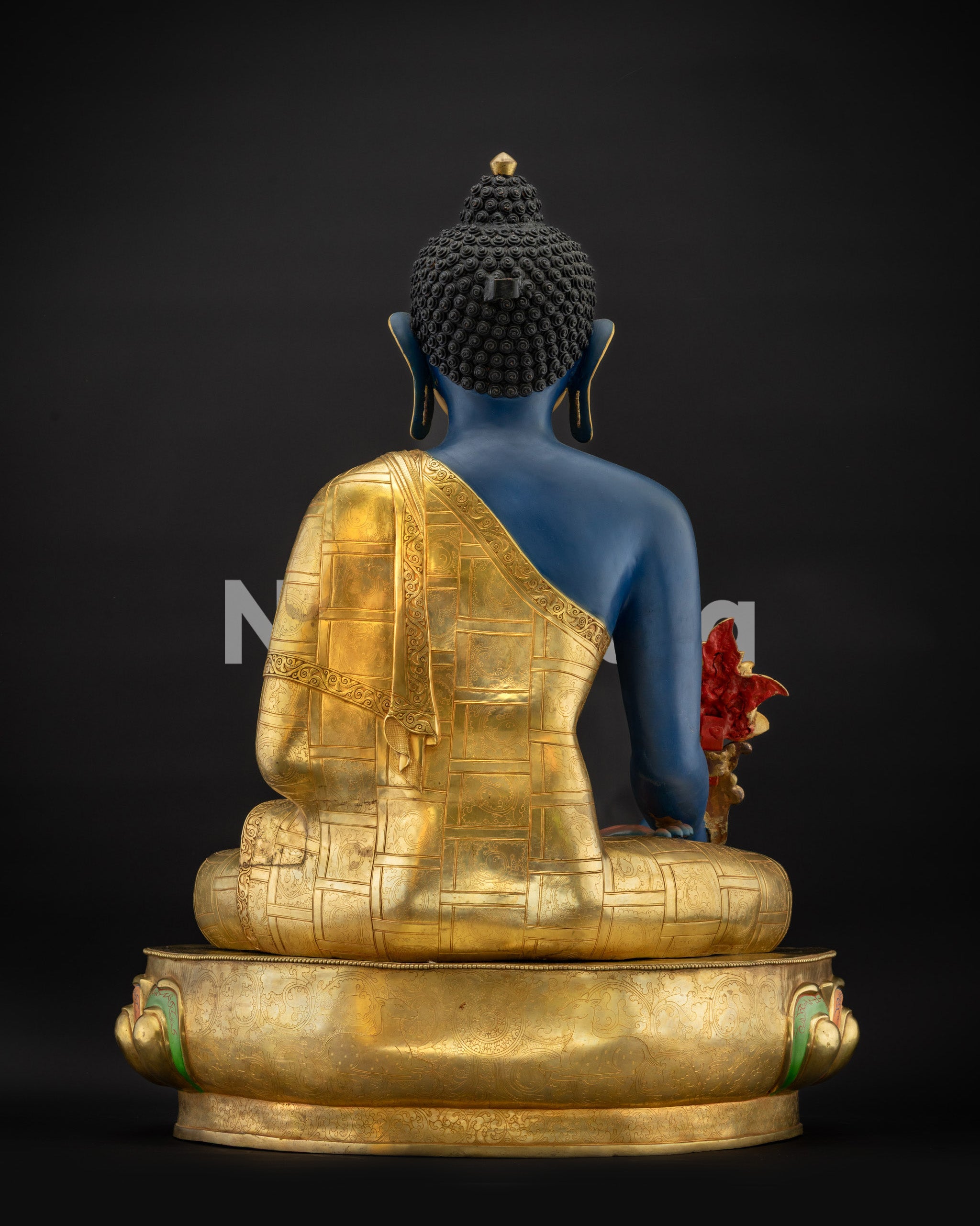 Back view of Nepalese Healing Medicine Buddha Statue highlighting carved monk robes and form