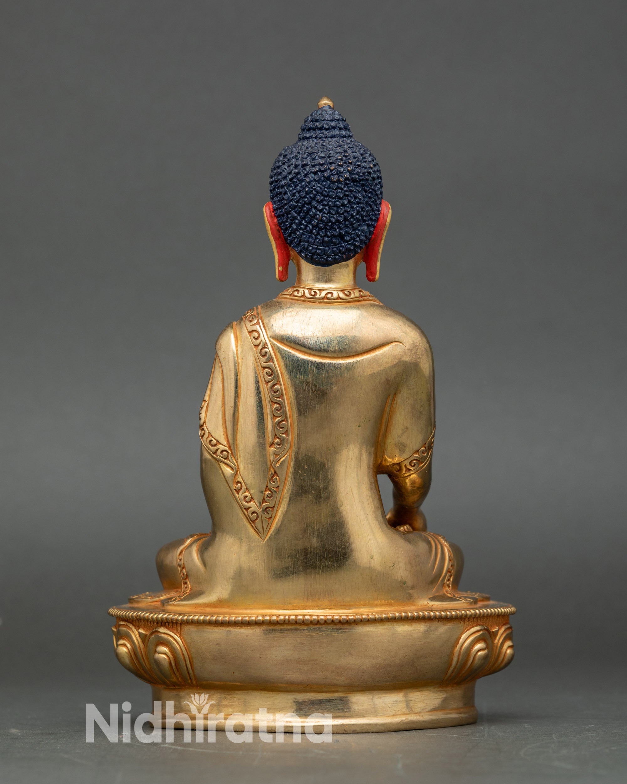 Back view of Ratnasambhava statue, engraved lotus base and detailed traditional carvings