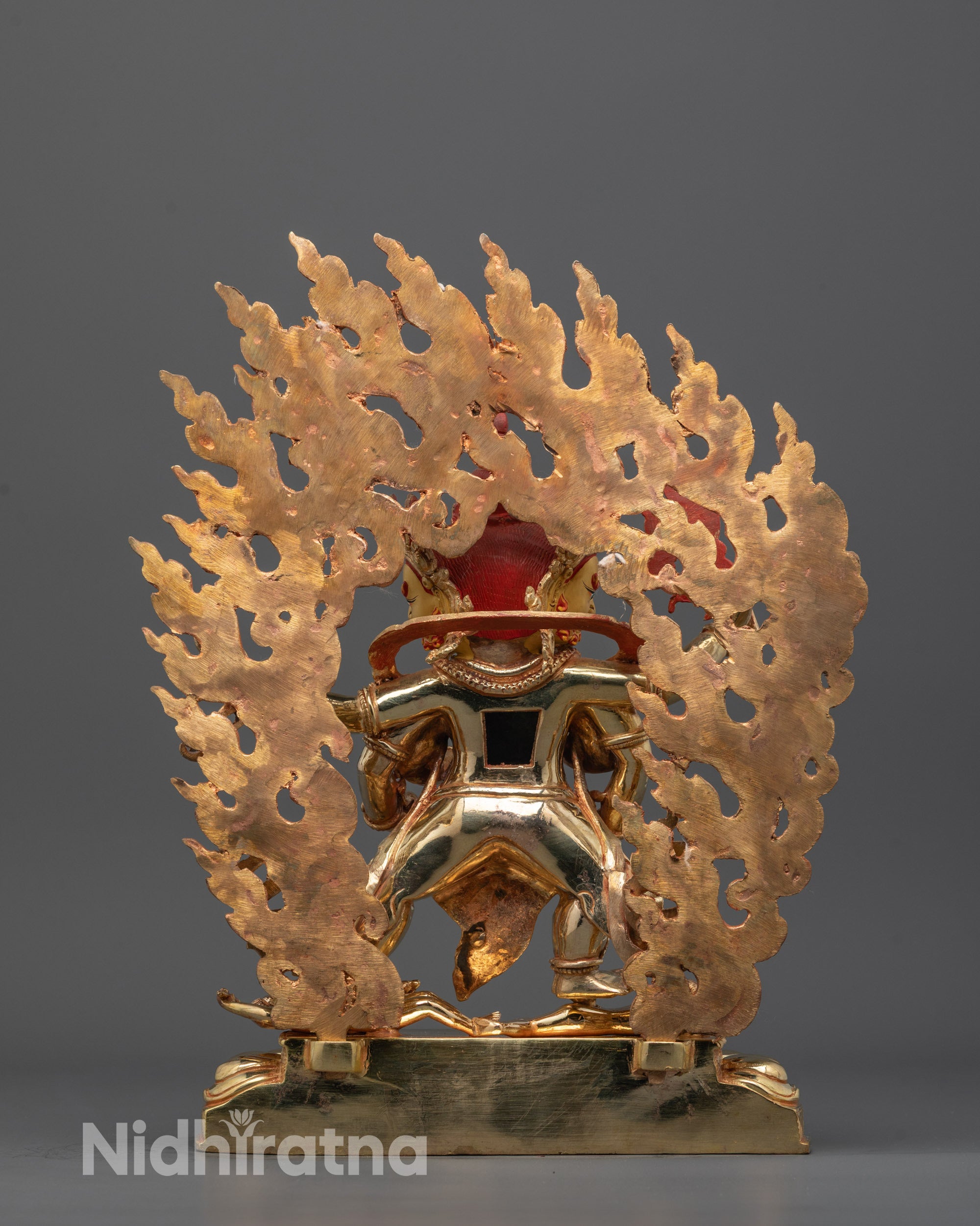 Back view of Red Dzambhala statue highlighting intricate craftsmanship and consecration chamber