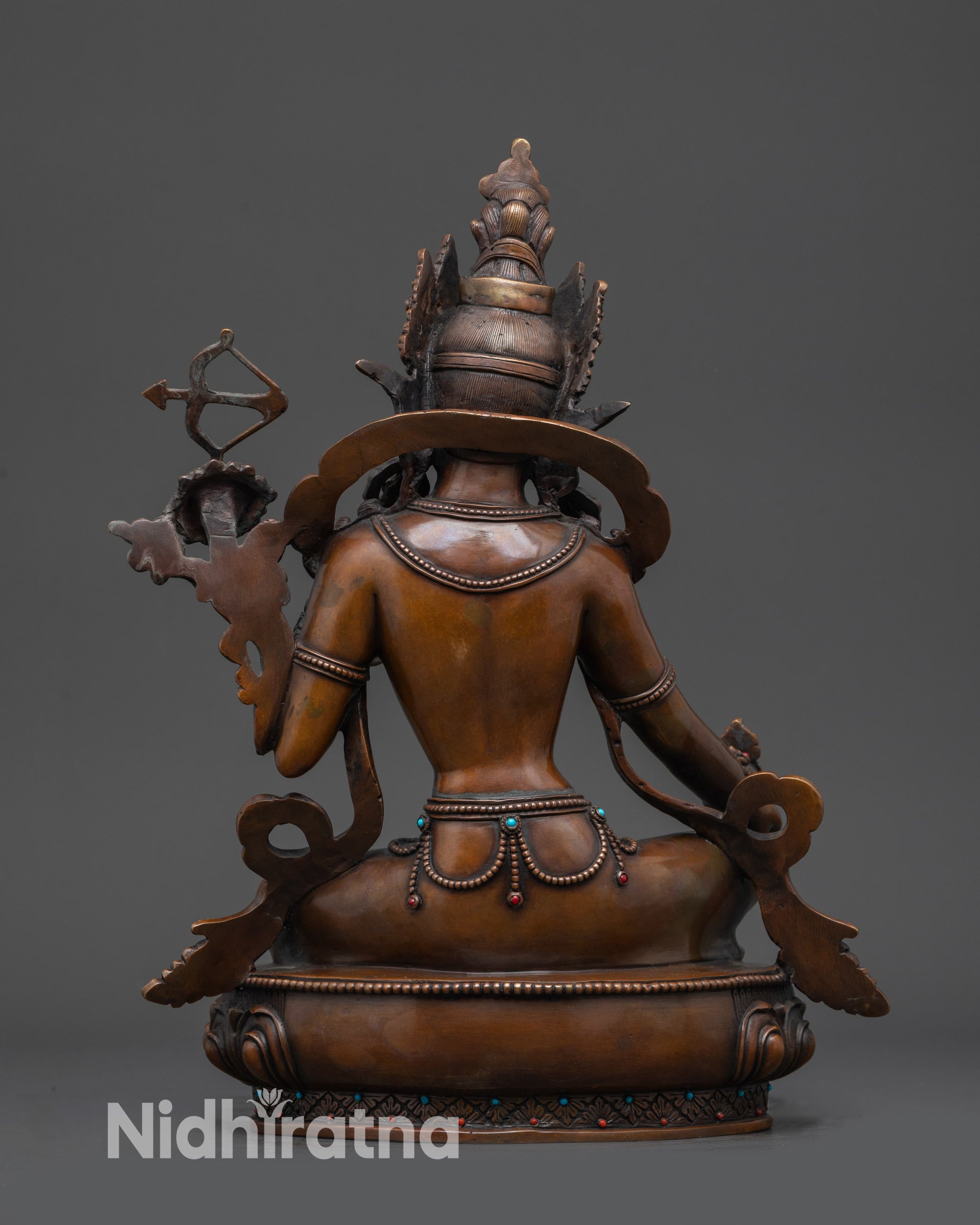 Back view of Red Tara statue highlighting intricate carvings and oxidized copper finish