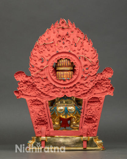 Back view of Sakya Mahakala statue with ornate flaming halo and carved details