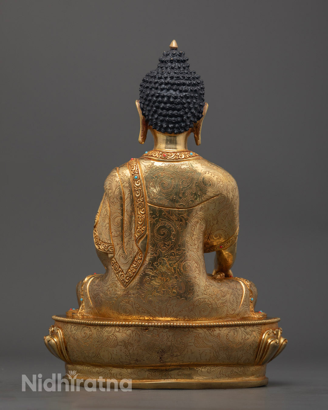 Shakyamuni Buddha sculpture highlighting the hollow chamber for mantras, silver-plated details, and ornate carvings on the robe.
