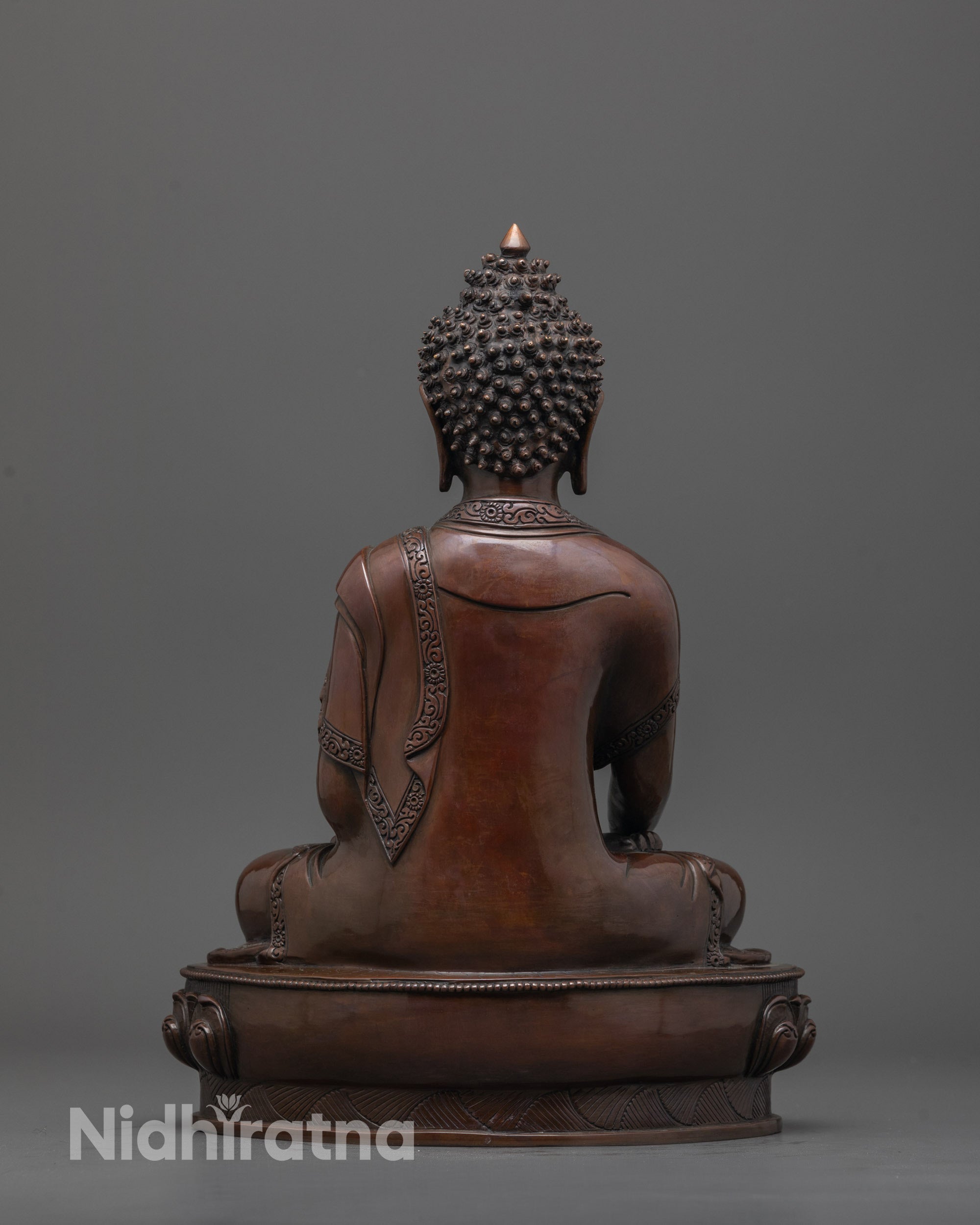 Back view of Shakyamuni Buddha statue highlighting intricate carvings and oxidized finish