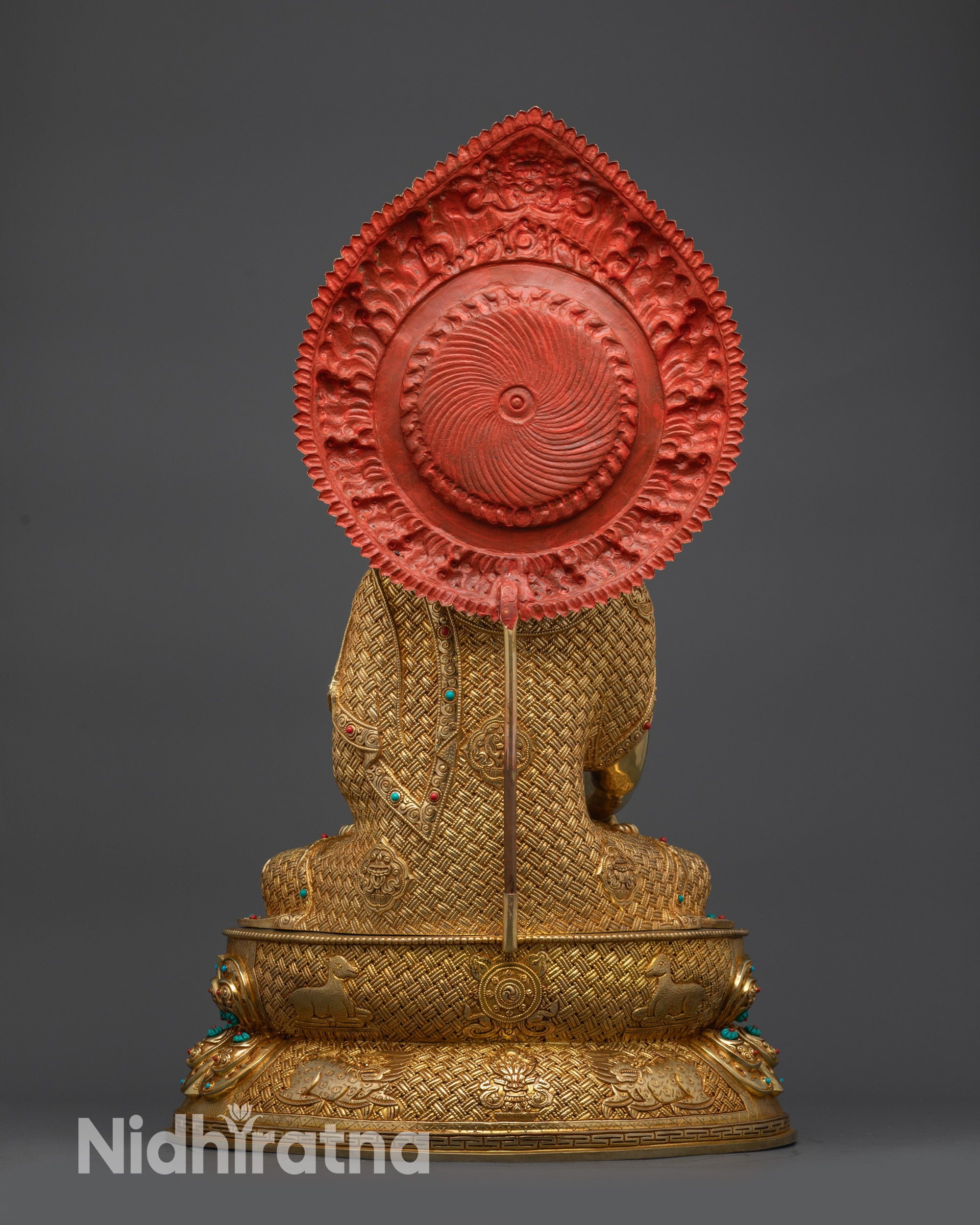 Back view of Shakyamuni Buddha statue showing ornate halo and polished finish