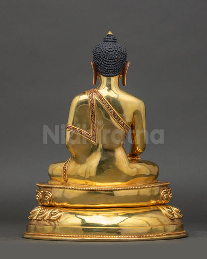 Back view of Siddhartha Gautama Buddha statue showing polished gold and lotus base