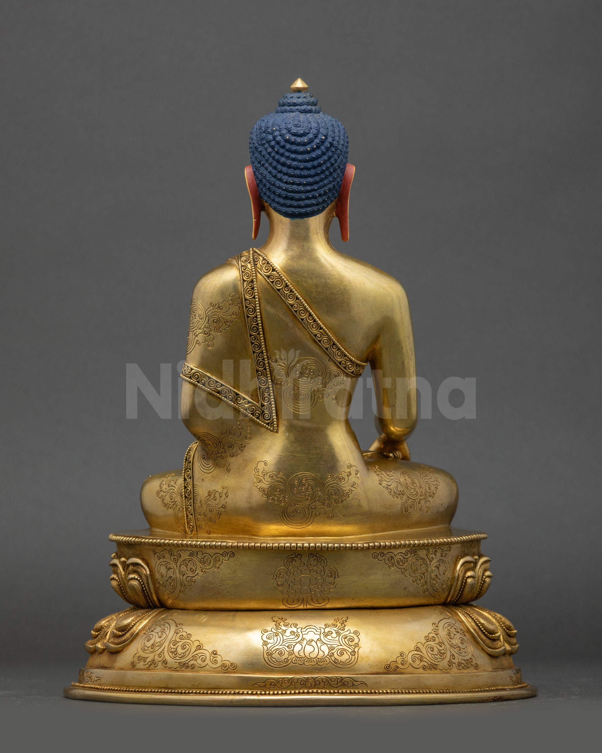 Back view of Tathagata Buddha Shakyamuni statue showing detailed robe engravings and lotus pedestal