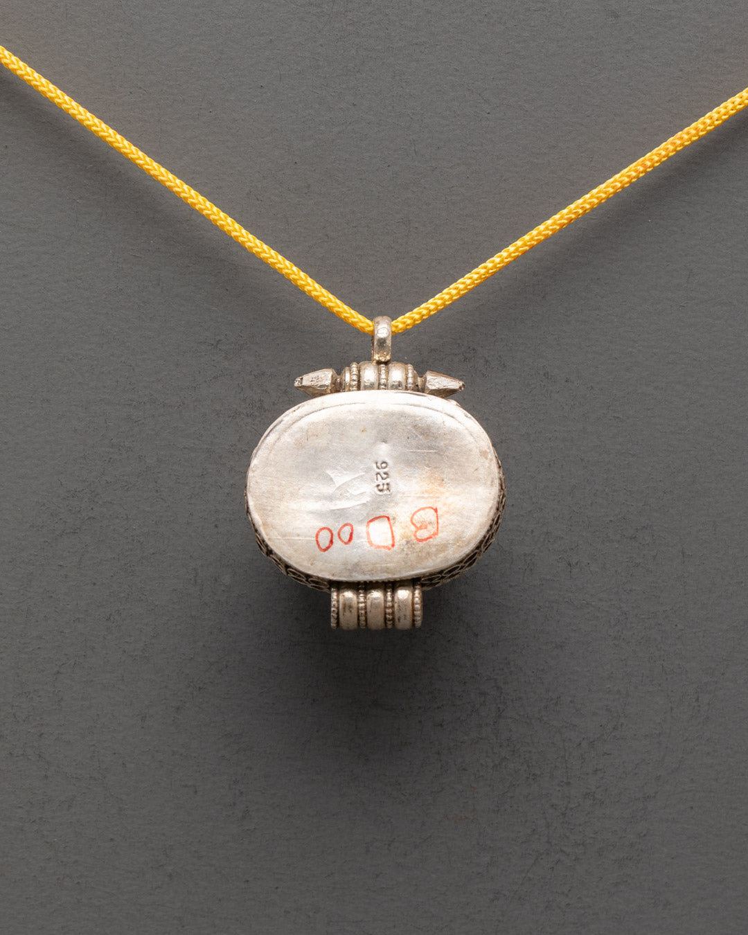 Back view of Tibetan Carnelian Locket displaying smooth silver finish and detailed carving


