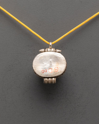 Back view of Tibetan Carnelian Locket displaying smooth silver finish and detailed carving


