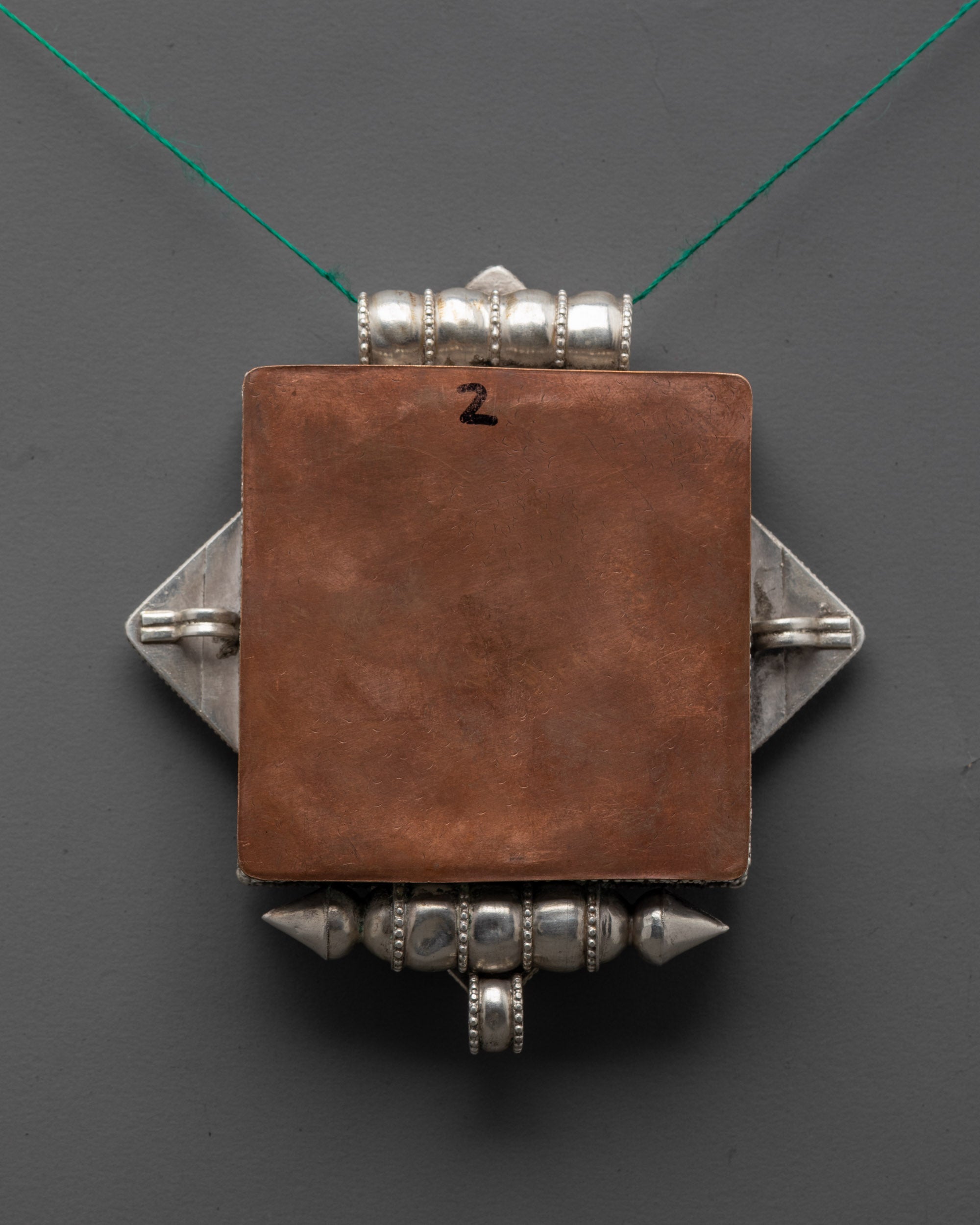 Back view of Tibetan Treasure Vase Locket pendant highlighting artisan craftsmanship and design