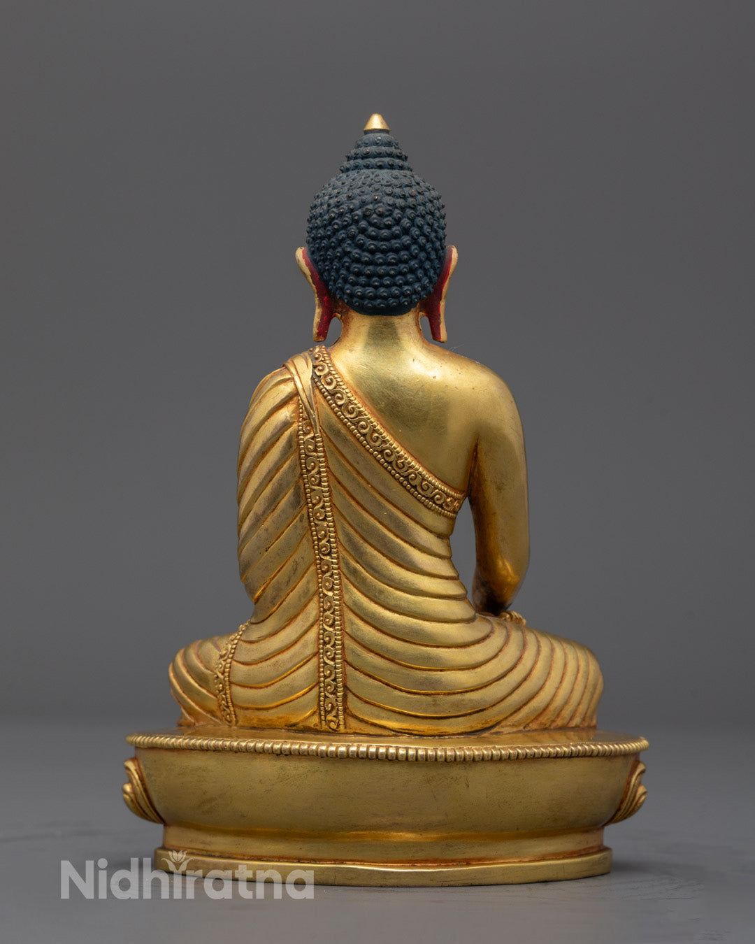 Back view of Traditional Nepalese artisan handcrafting a Shakyamuni Buddha sculpture
