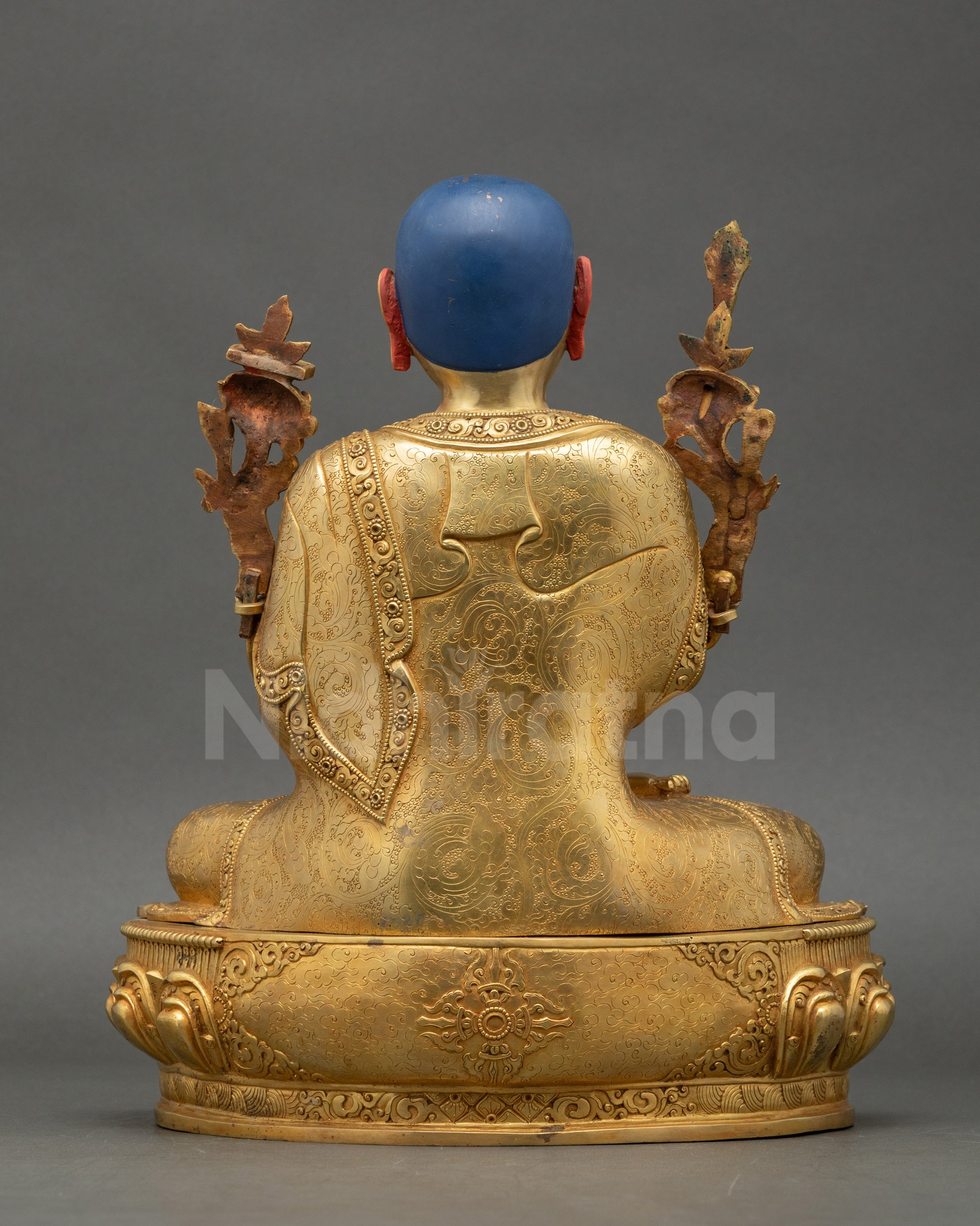 Back view of Tsongkhapa statue showing detailed robe patterns and lotus base