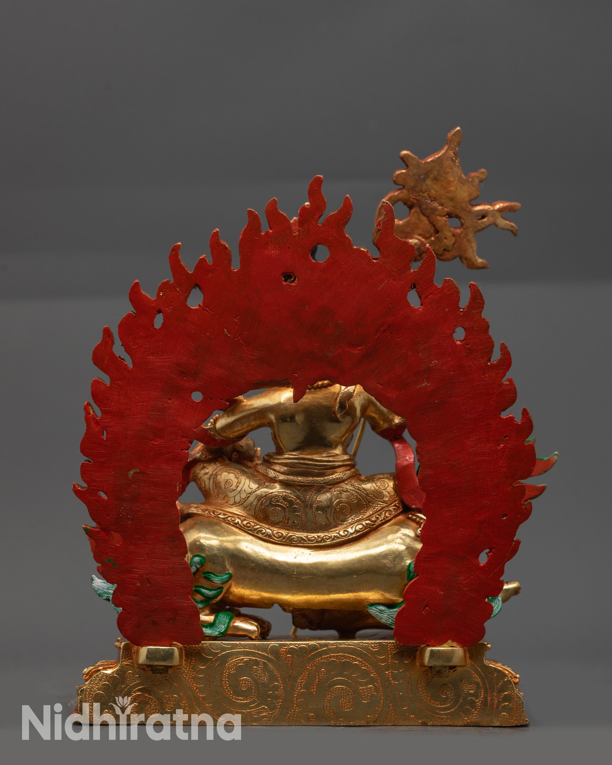 Back view of Vaishravana Namtoshe statue highlighting detailed carvings and swirling robe