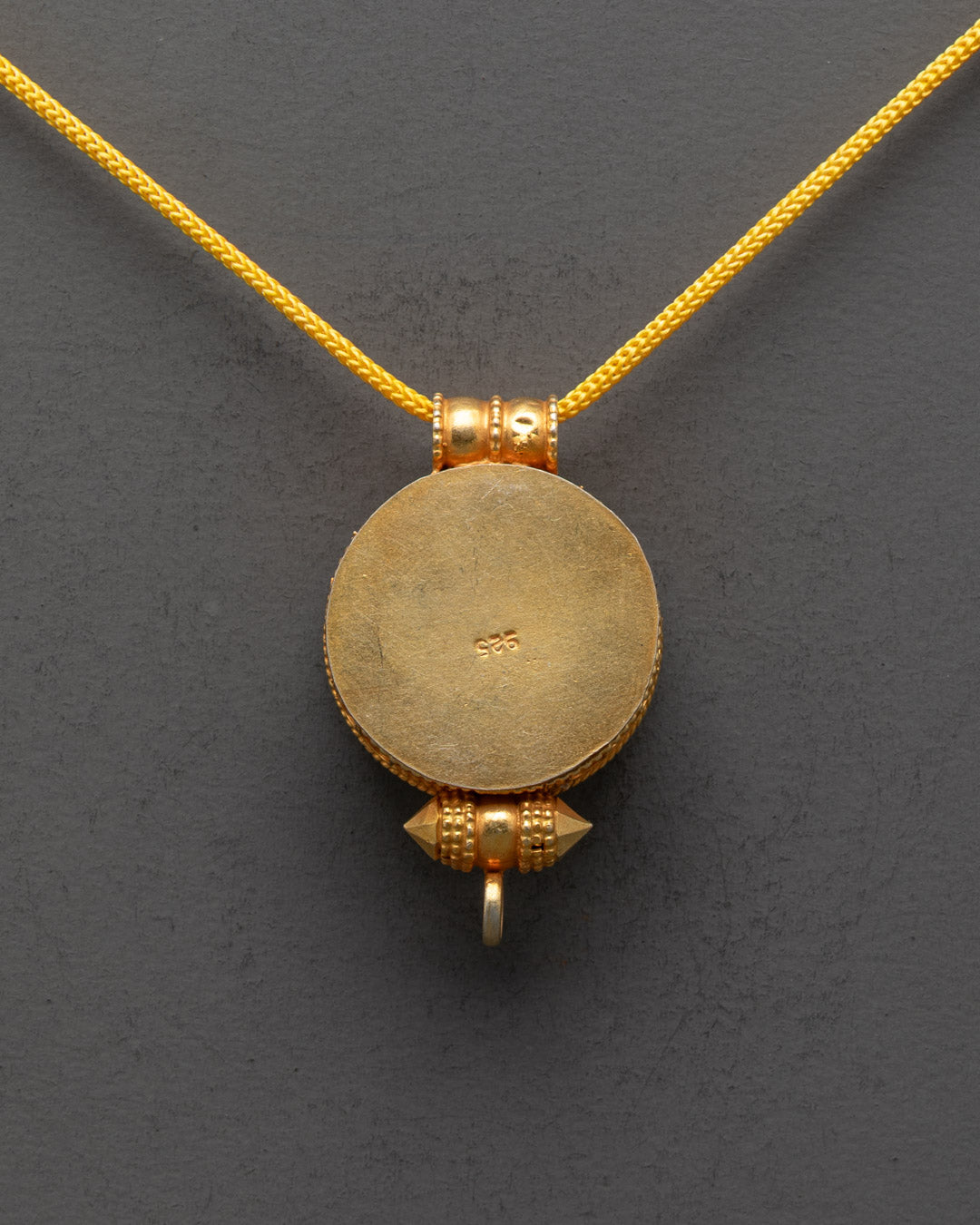 Back view of Wheel of Dharma Locket with unique hand-carved patterns and gold finish