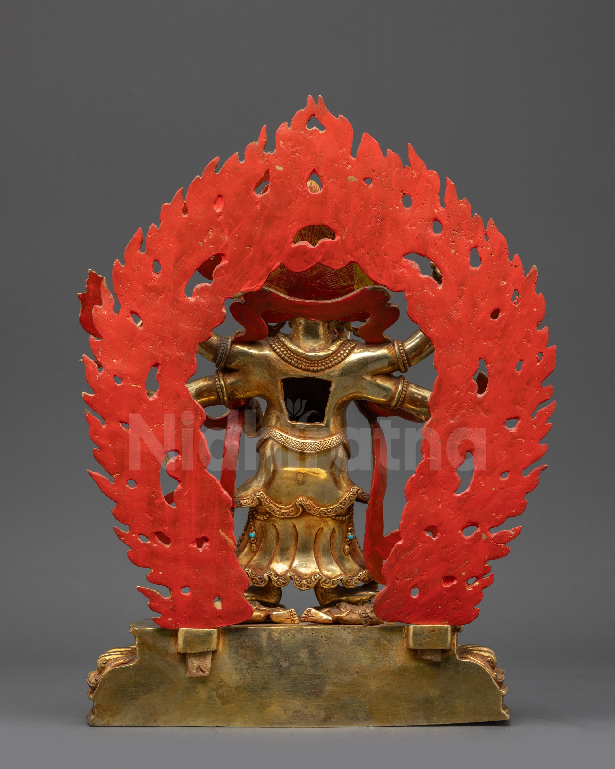 Back view of White Mahakala statue displaying carved lower garments and giant halo
