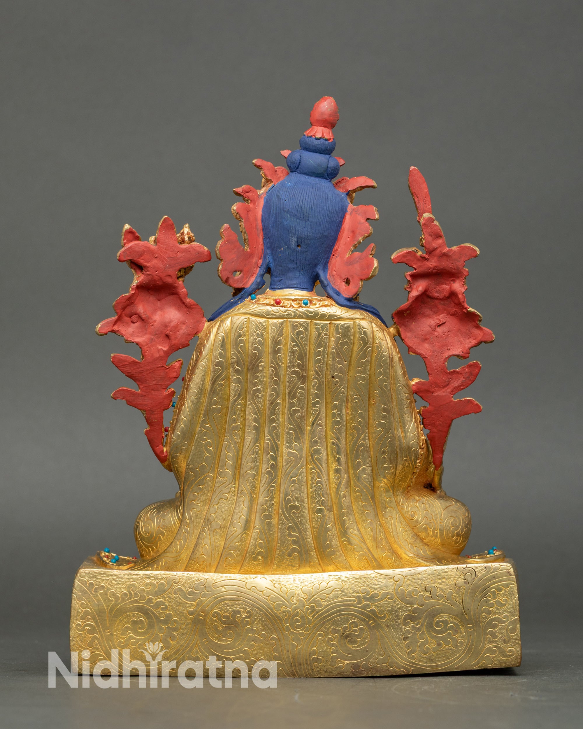 Back view of Yuthok Yonten Gonpo sculpture showing carved pedestal and robe patterns