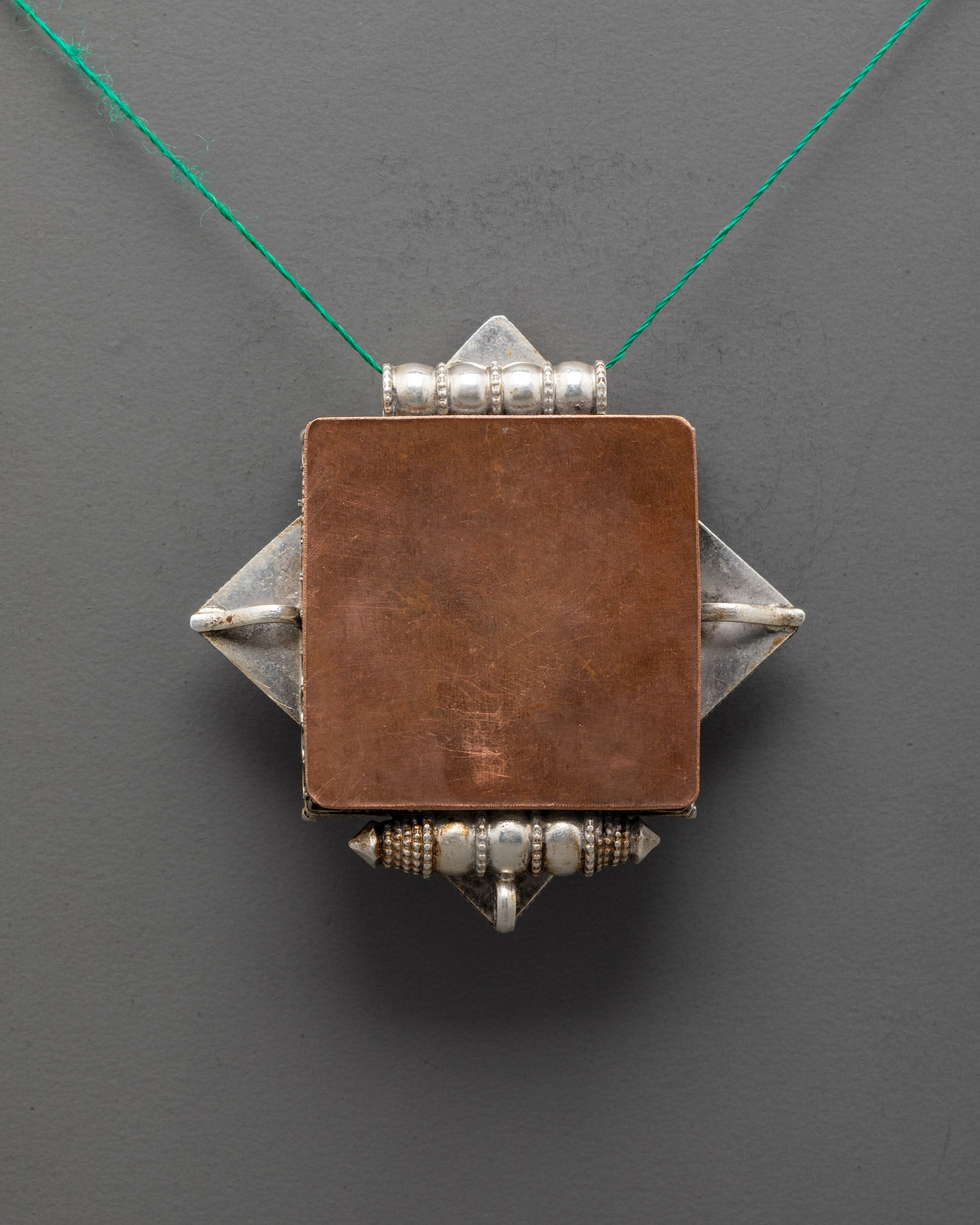 Back view of artisan-crafted Treasure Vase Locket Necklace showcasing detailed silver carving