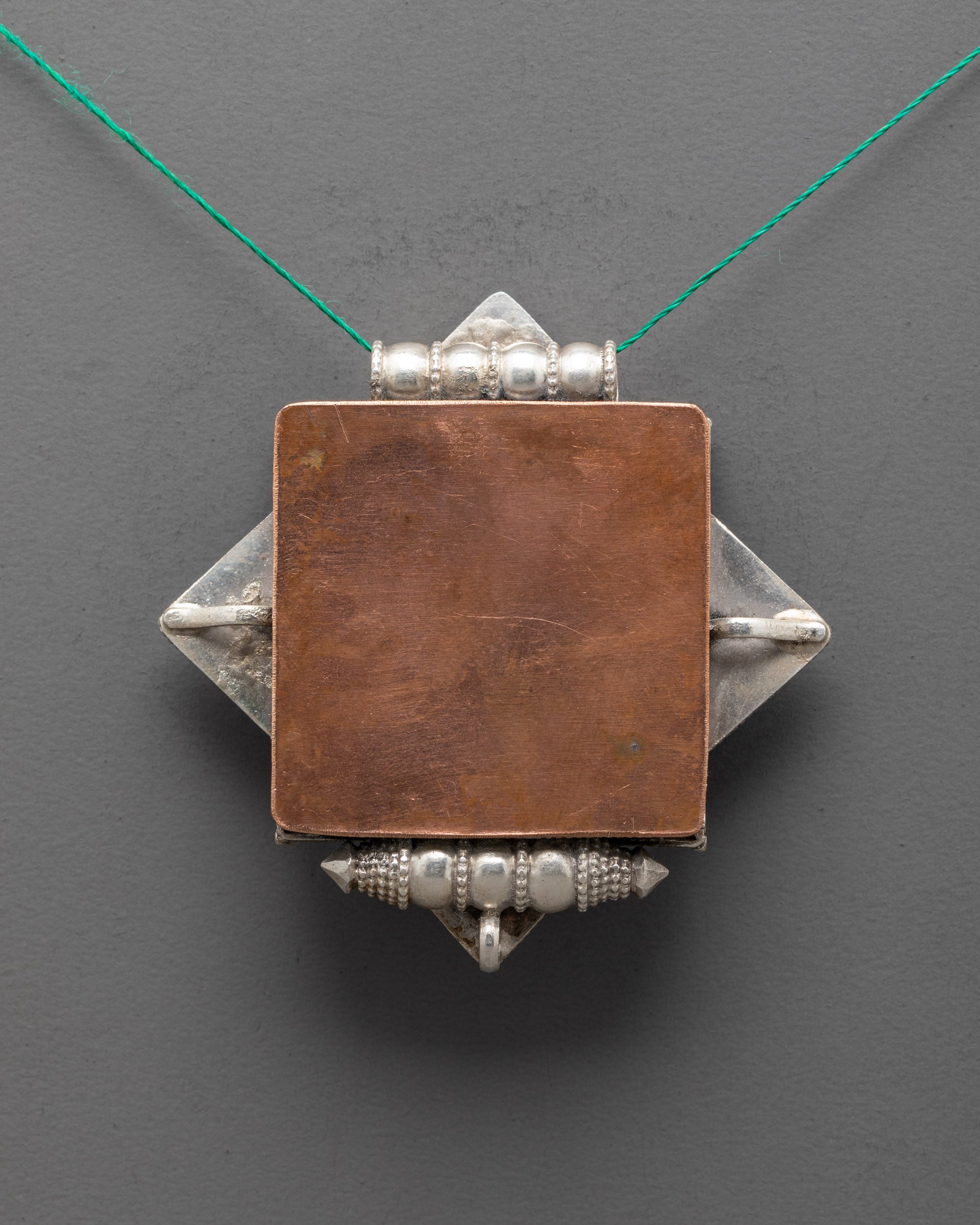 Back view of artisan-made Dharma Wheel Locket with detailed silver craftsmanship