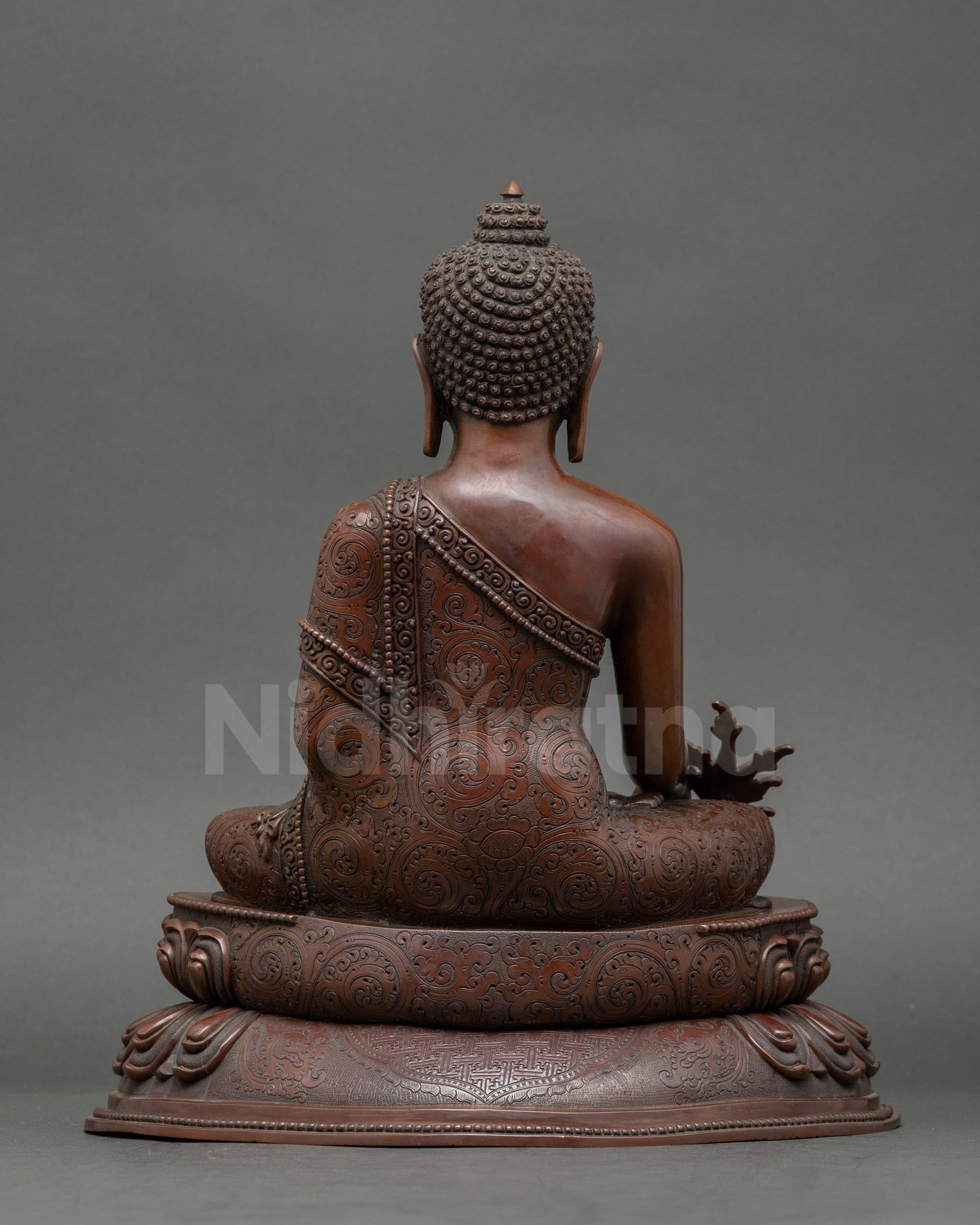 Back view of gold-gilded Medicine Buddha sculpture for meditation and home altar