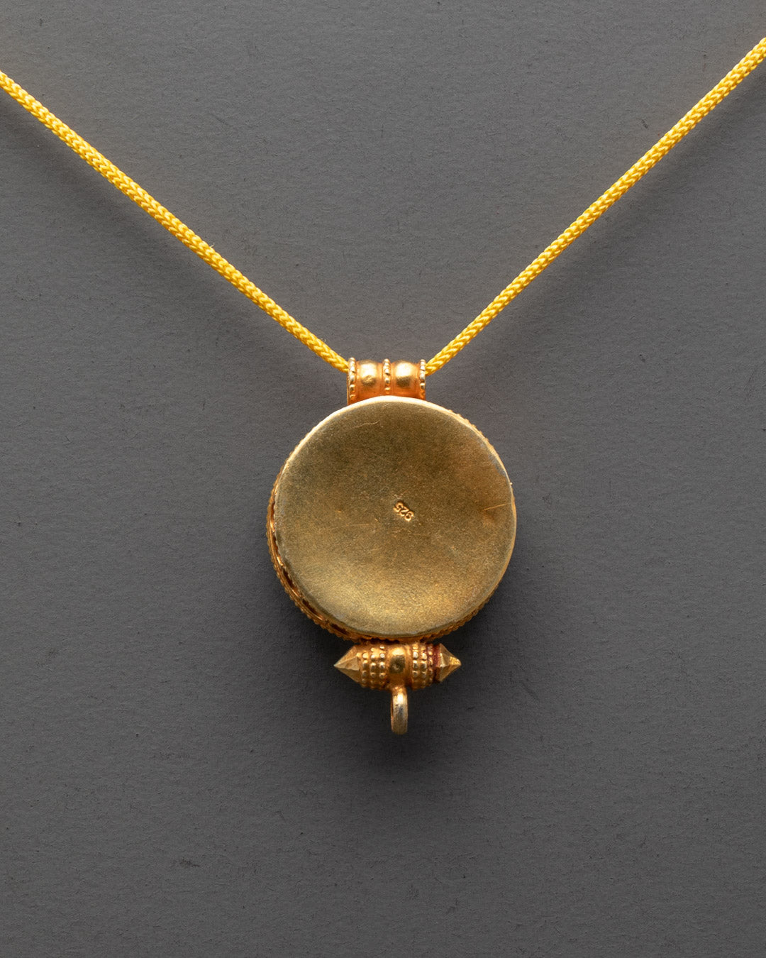 Back view of gold-gilded Tibetan Ghau Amulet Locket showing intricate carved details
