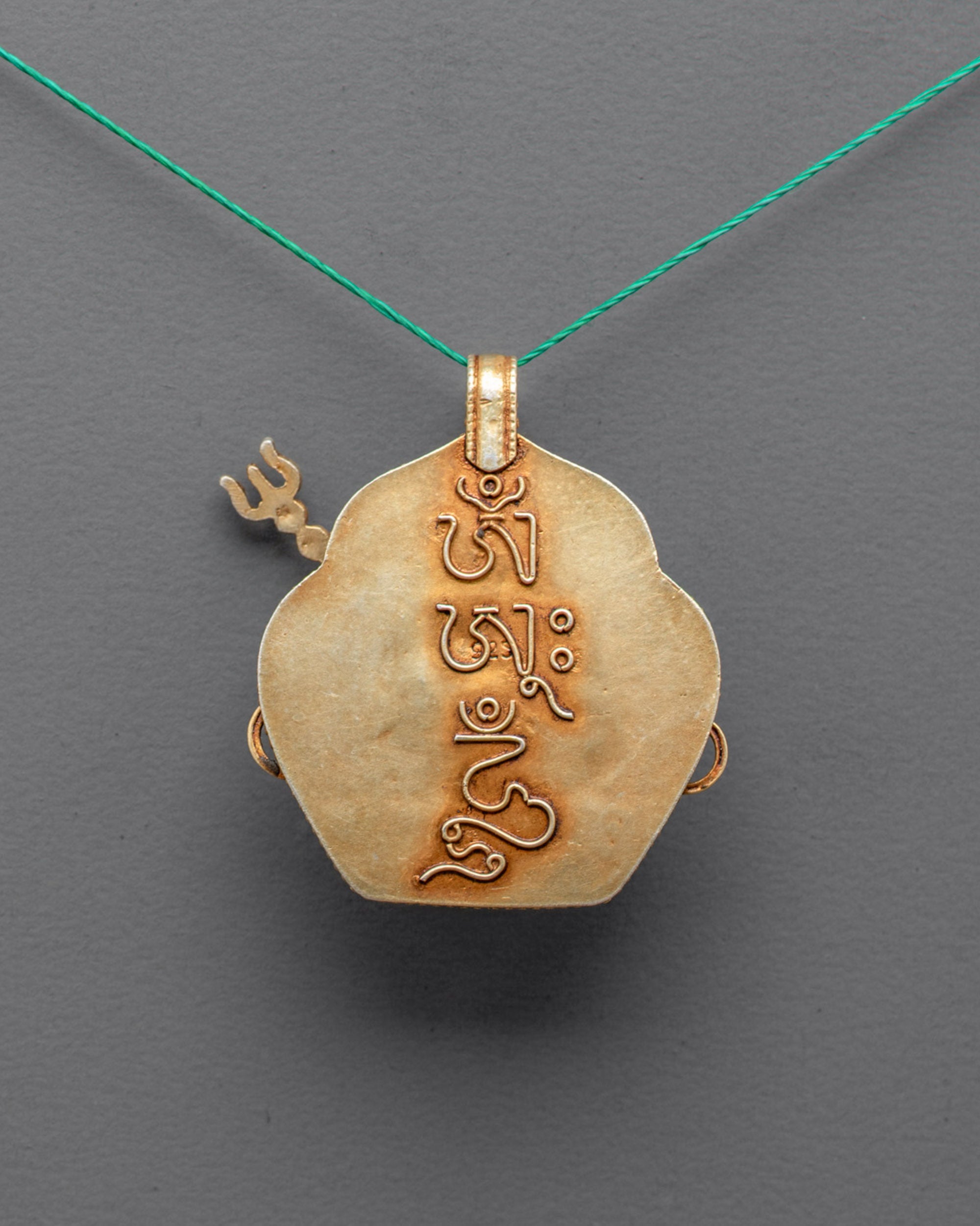 Back view of gold-plated Guru Rinpoche locket highlighting artisan craftsmanship and details