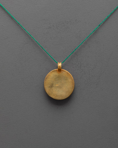Back view of gold-plated copper Parasol Locket highlighting artisan carving and finish