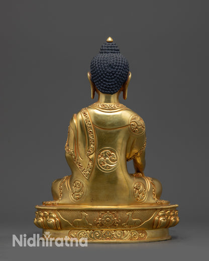 Back view of gold fire-gilded Shakyamuni Buddha statue showing detailed monk’s robe patterns.