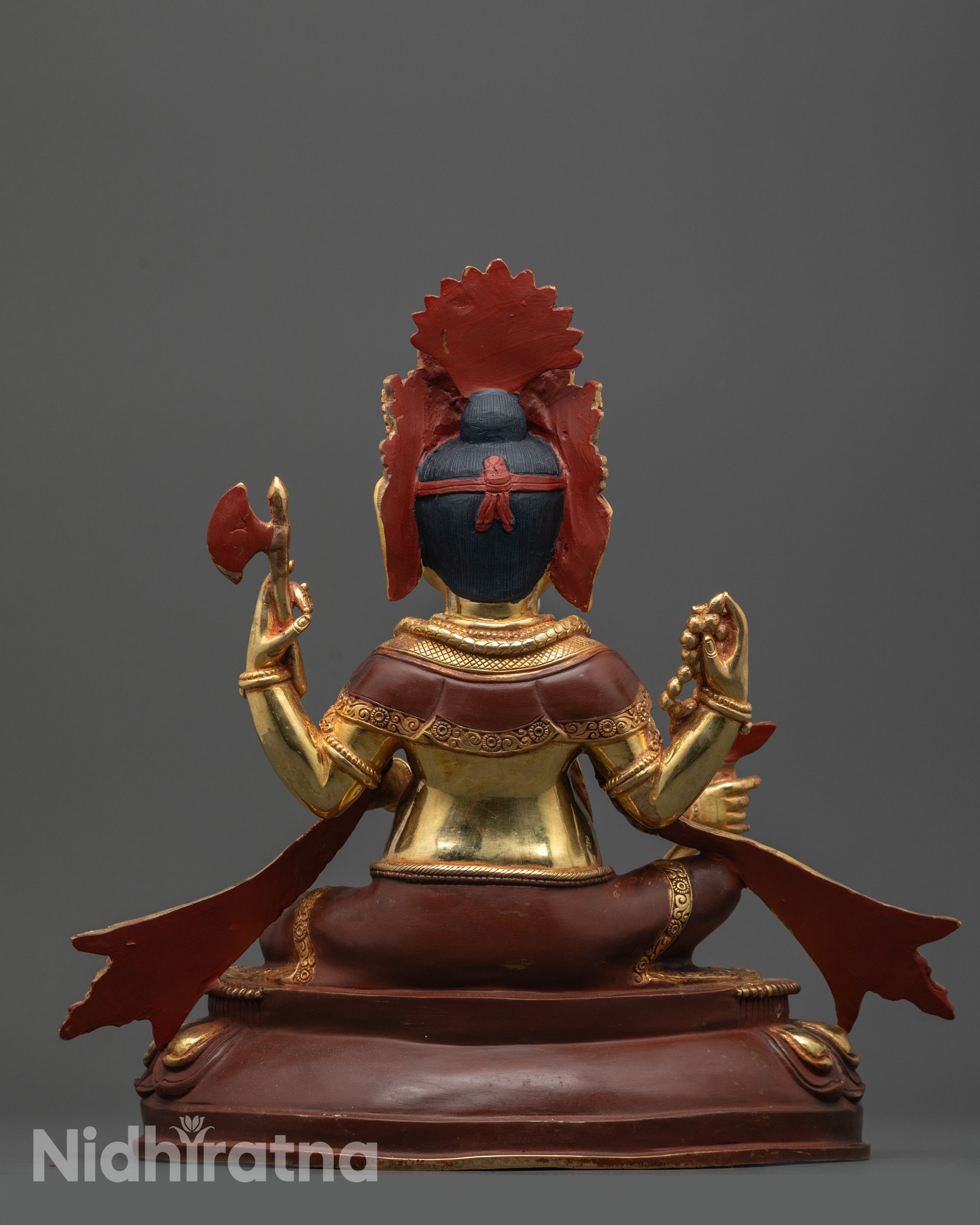 Back view of handcrafted Ganesh statue seated on lotus with calm facial expression