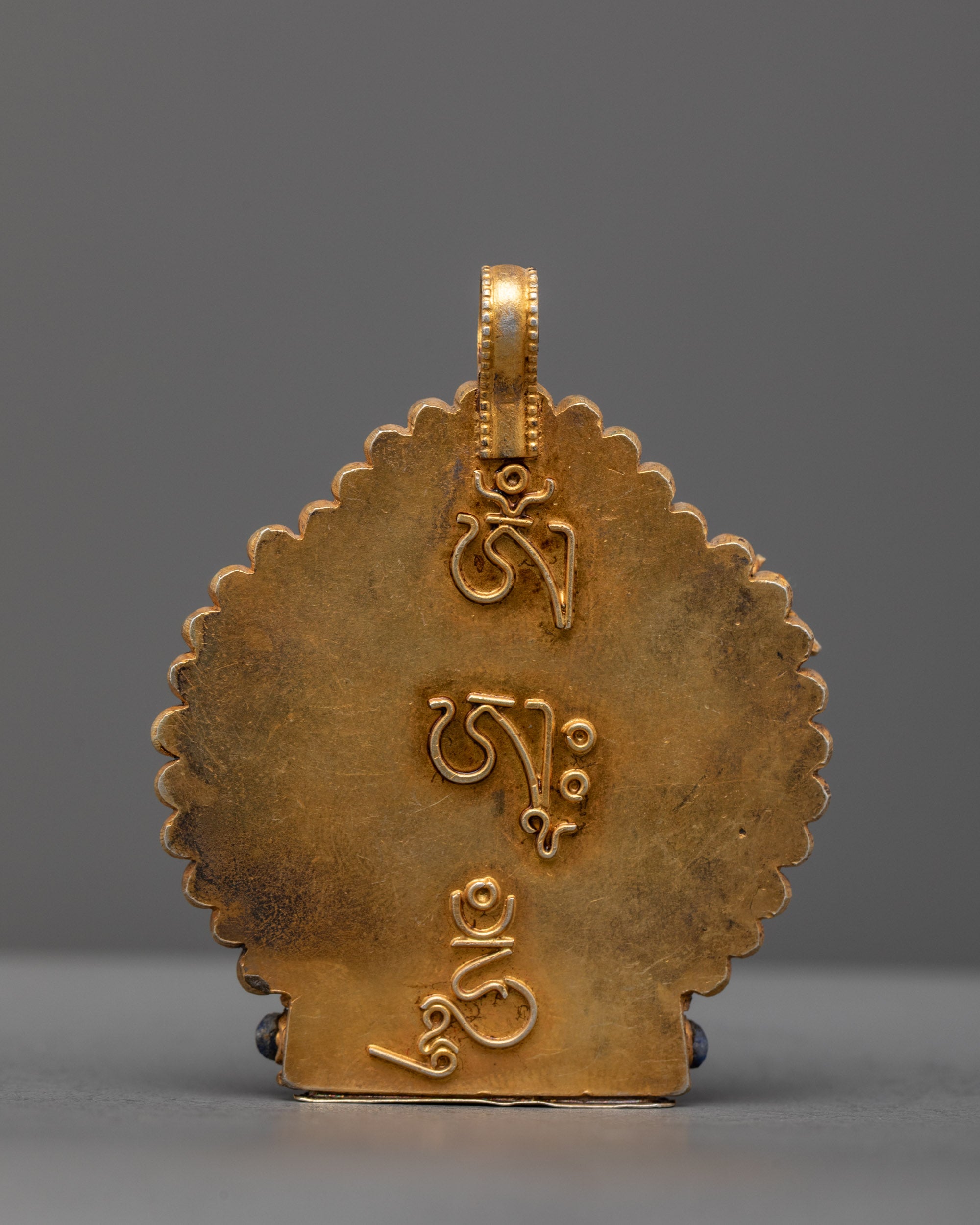 Back view of handcrafted Manjushri amulet with finely carved gold filigree from Patan, Nepal