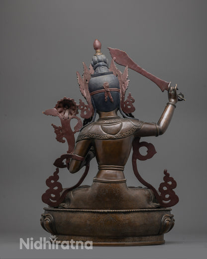 Back view of handcrafted Manjushri statue with oxidized copper texture and lotus seat