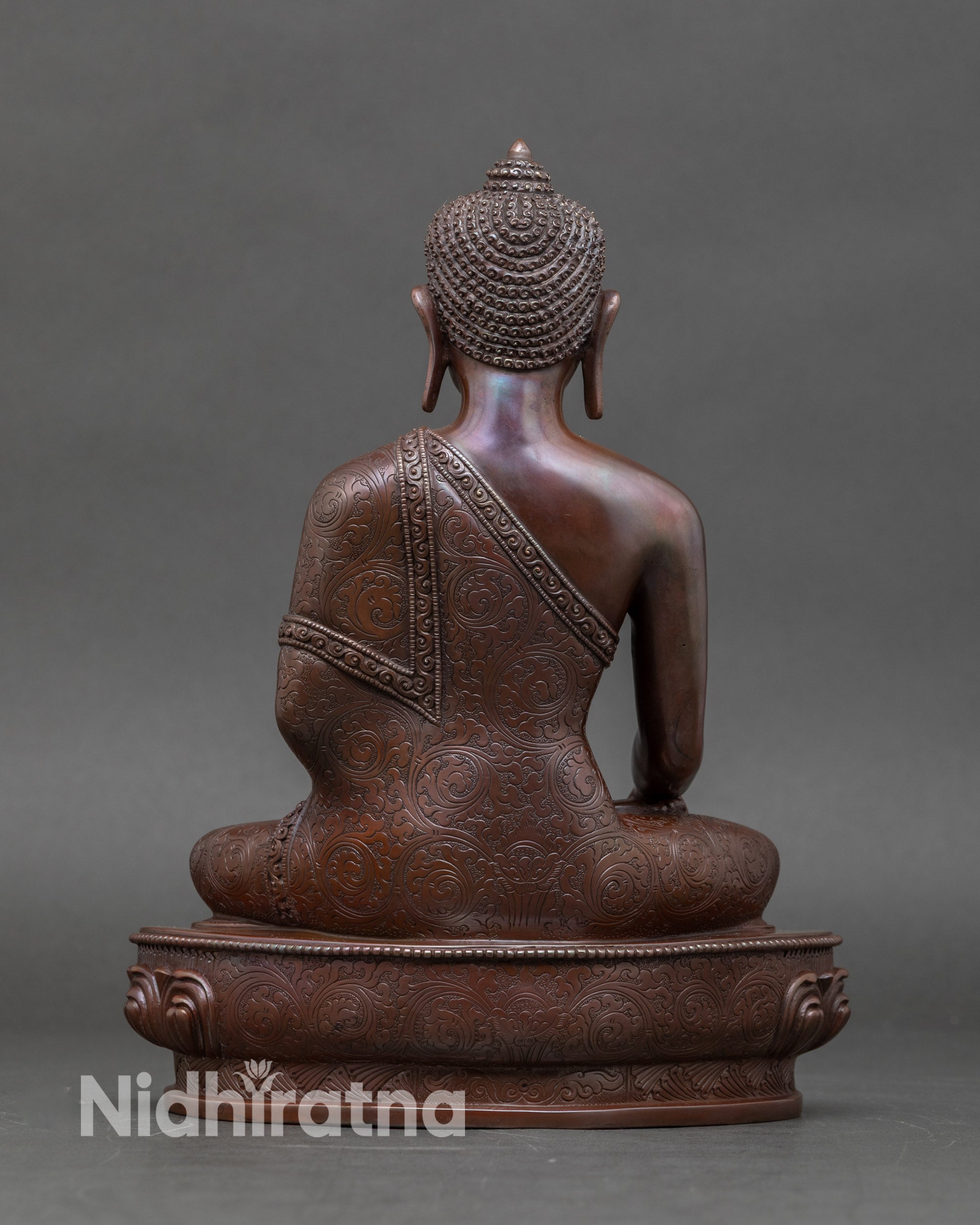 Back view of handcrafted Newari Buddha statue, intricate copper details and oxidized finish