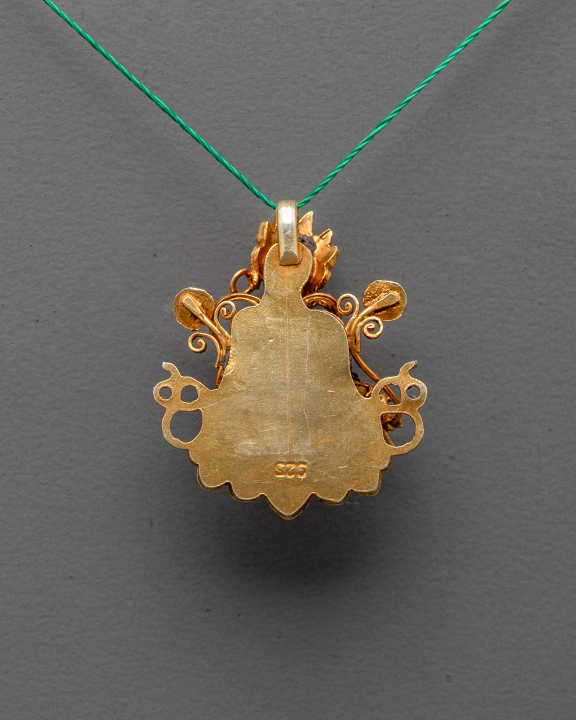 Back view of handcrafted Tibetan Green Tara pendant showcasing artisan craftsmanship