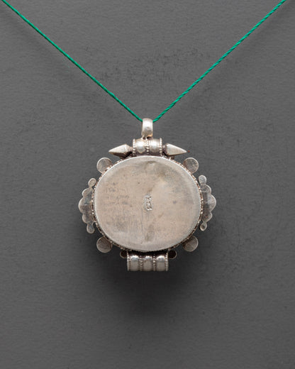 Back view of intricately carved silver locket pendant with traditional Himalayan craftsmanship