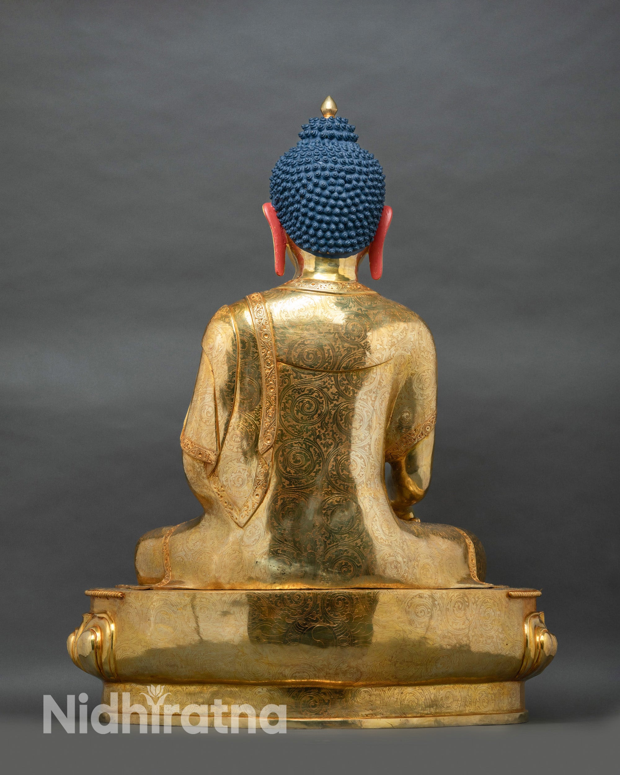Back view of large copper Shakyamuni Buddha statue with gold fire-gilded robe and engraved motif detailing